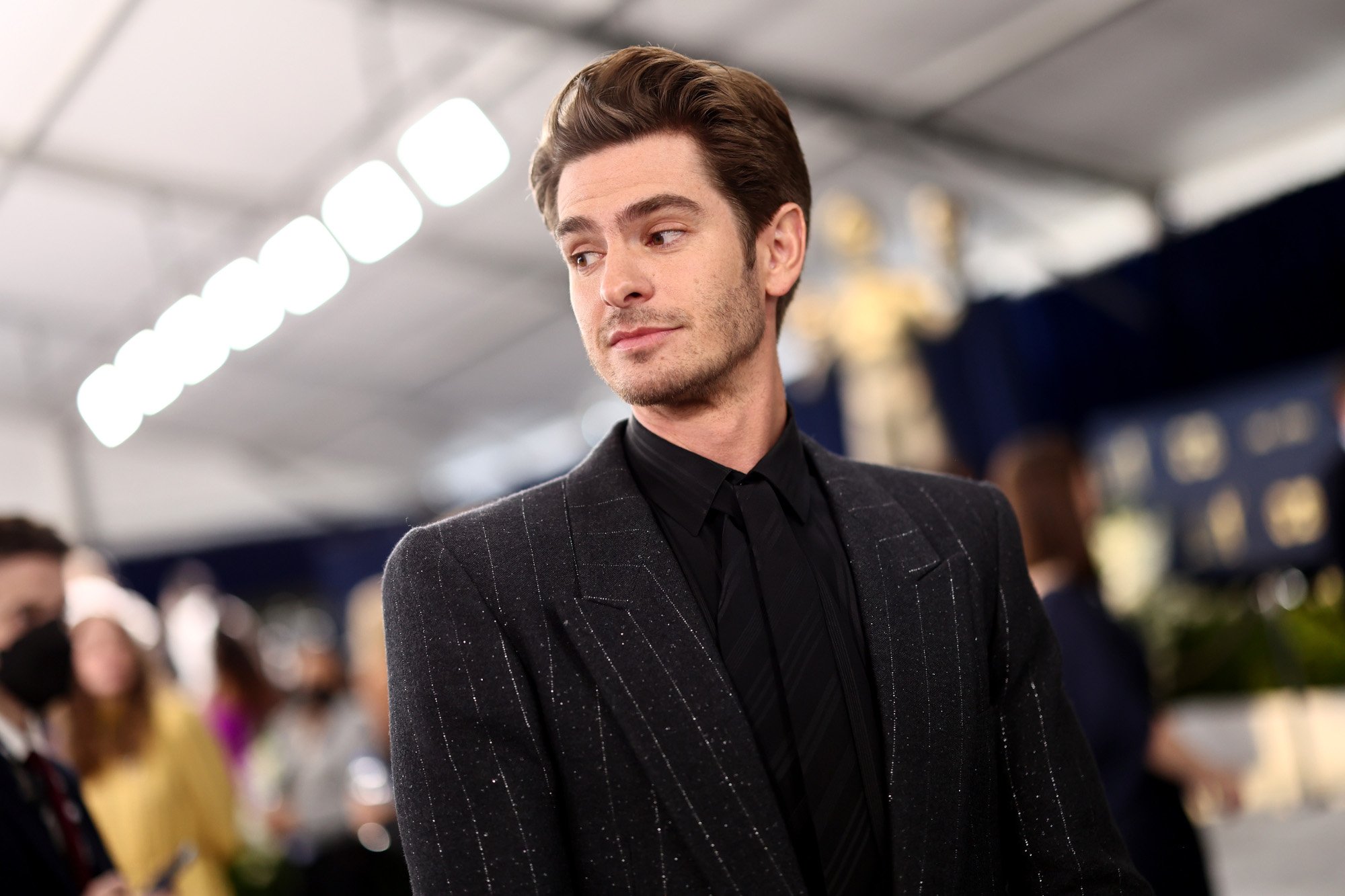 'Spider-Man: No Way Home' star Andrew Garfield attends the 2022 SAG Awards. He's wearing a black shirt and suit and looking to the side of the camera.