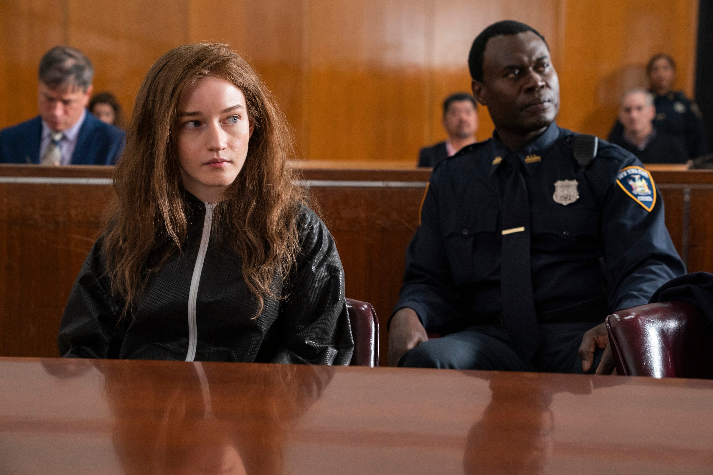 'Inventing Anna' Julia Garner portrays Anna Delvey in her court fashion clothing with an officer behind her