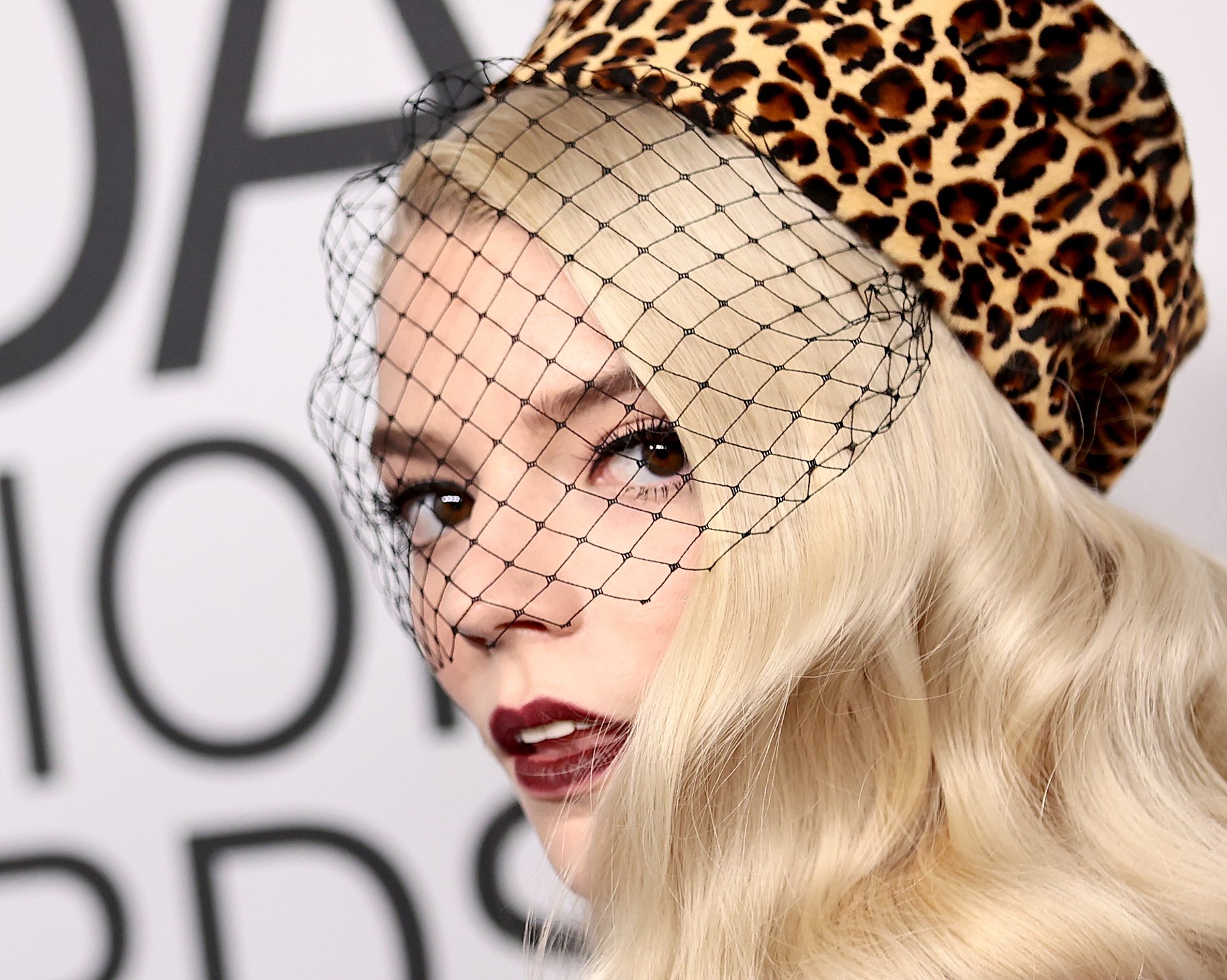 A close-up of Anya Taylor-Joy's face that's concealed by a fashionable net and hat. Taylor-Joy stars in 'Peaky Blinders' Season 6 Episode 1