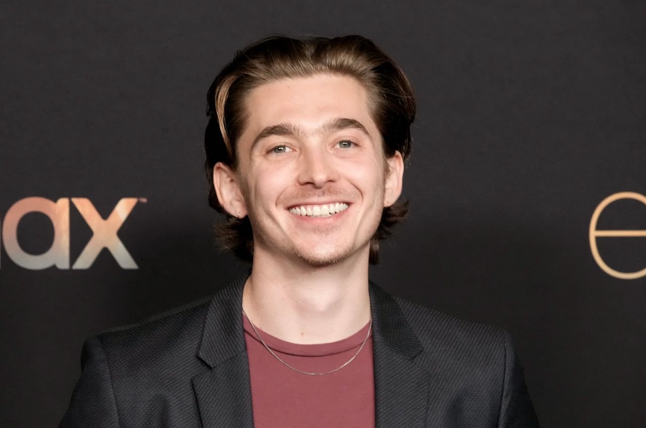Austin Abrams attends HBO's "Euphoria" Season 2 in a red shirt and black blazer.