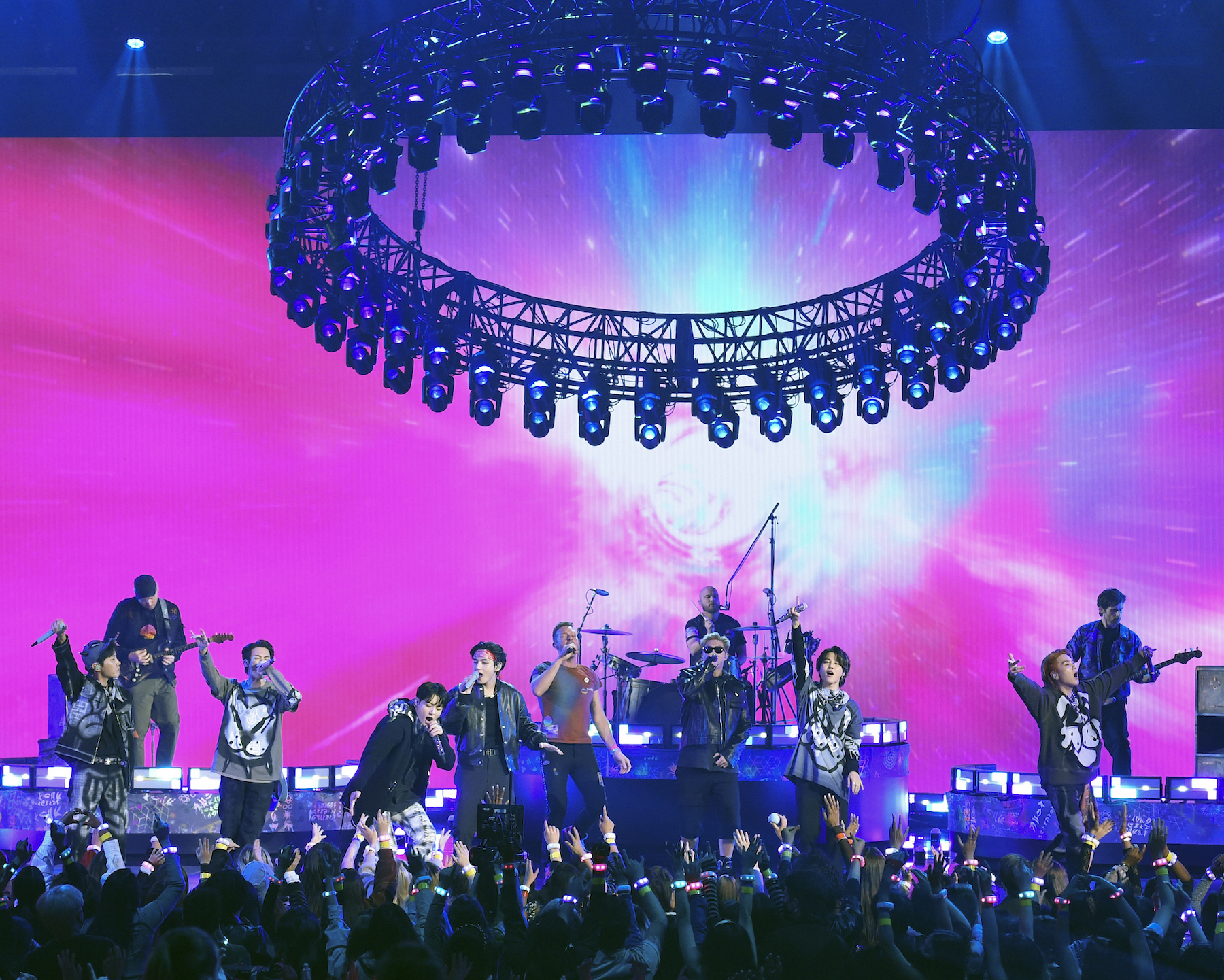 Chris Martin and Coldplay perform 'My Universe' with BTS at the 2021 American Music Awards with a pink background and black and gray outfits