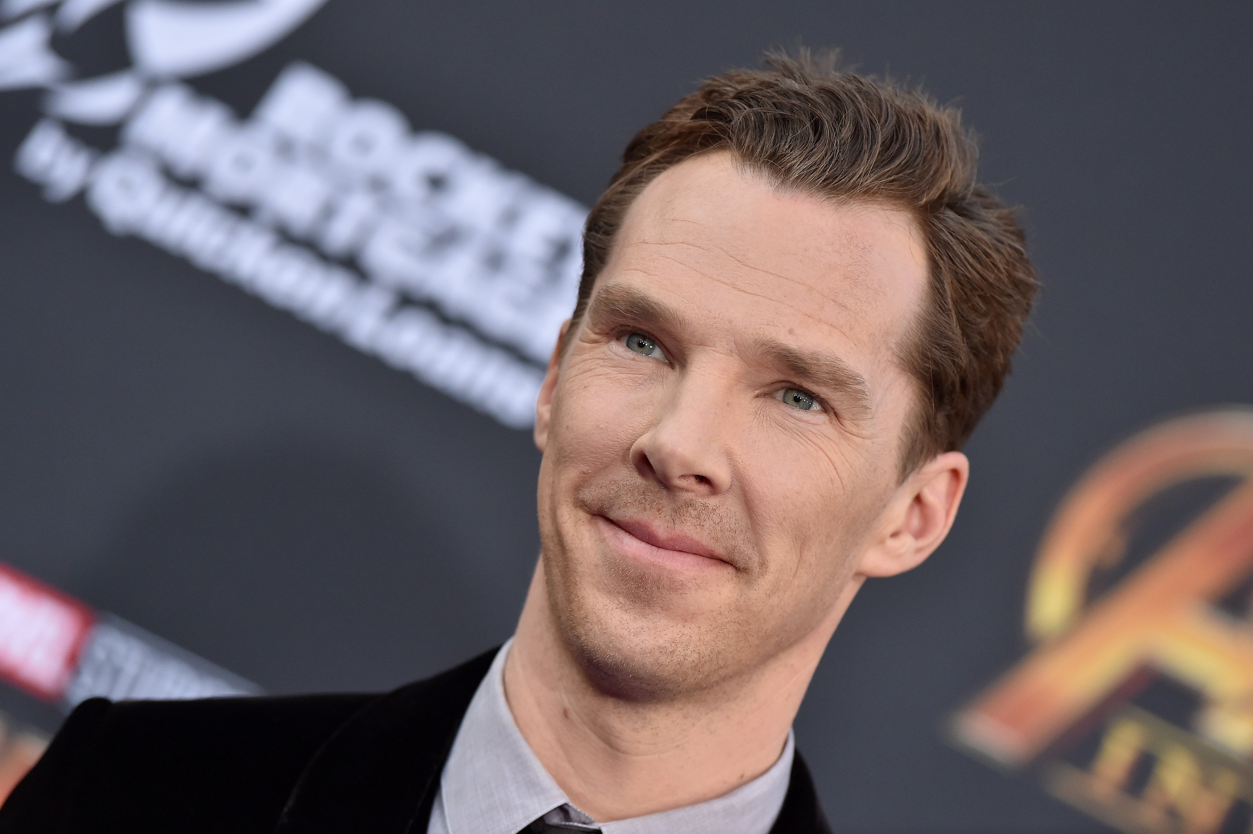 Benedict Cumberbatch, who is seen in the new 'Doctor Strange in the Multiverse of Madness' poster, wears a black suit over a gray button-up shirt and black tie.