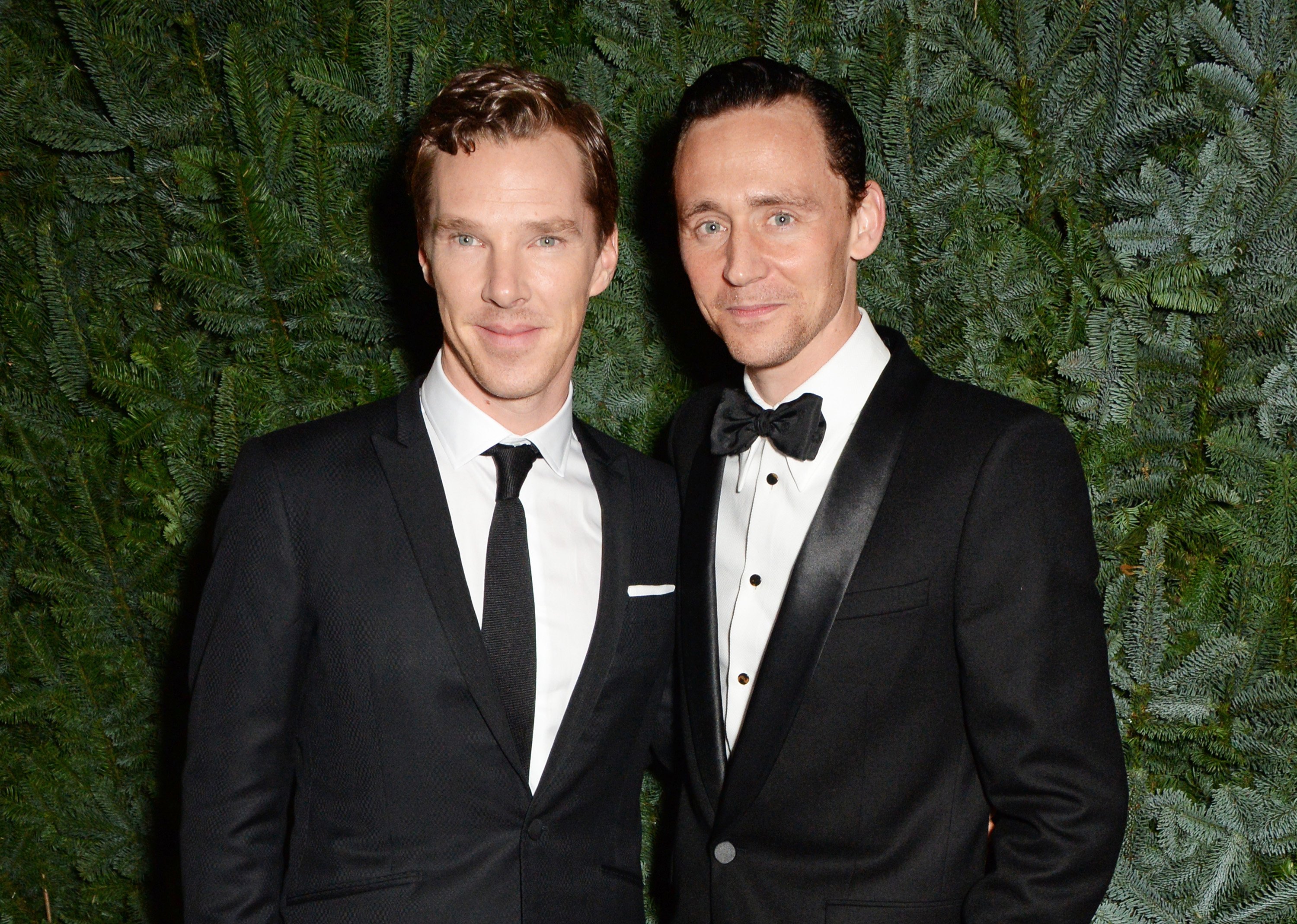 'Doctor Strange 2' star Benedict Cumberbatch and 'Loki' star Tom Hiddleston pose for pictures. Cumberbatch wears a black suit over a white button-up shirt and black tie. Hiddleston wears a black tux with a black bow tie.