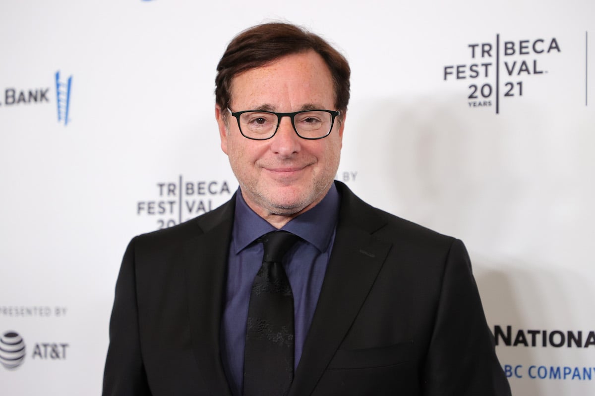 Bob Saget smiles and poses at an event.