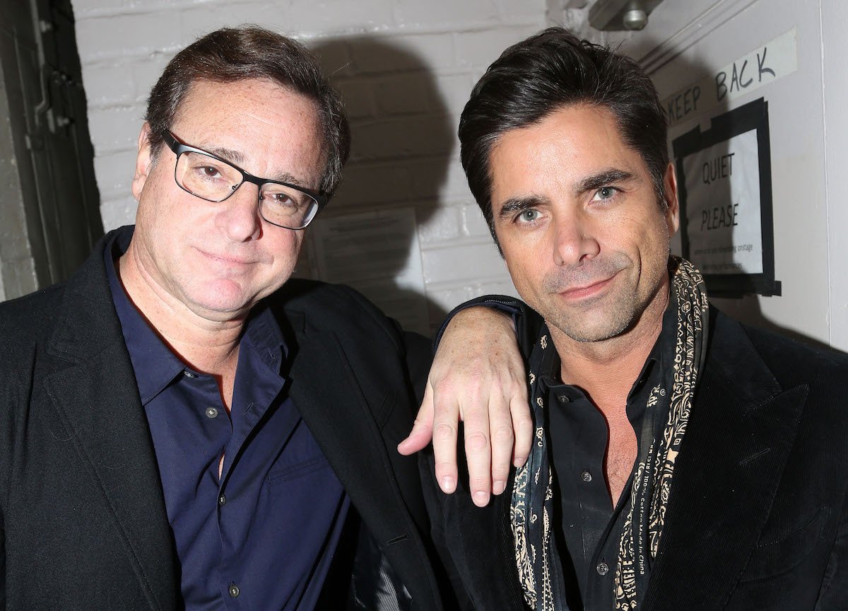 Bob Saget and John Stamos pose together at an event.