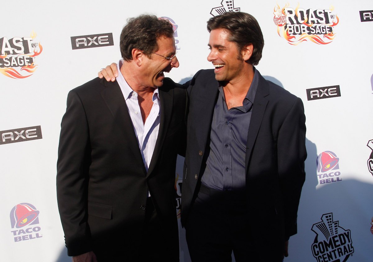 Bob Saget and John Stamos laugh together at an event.