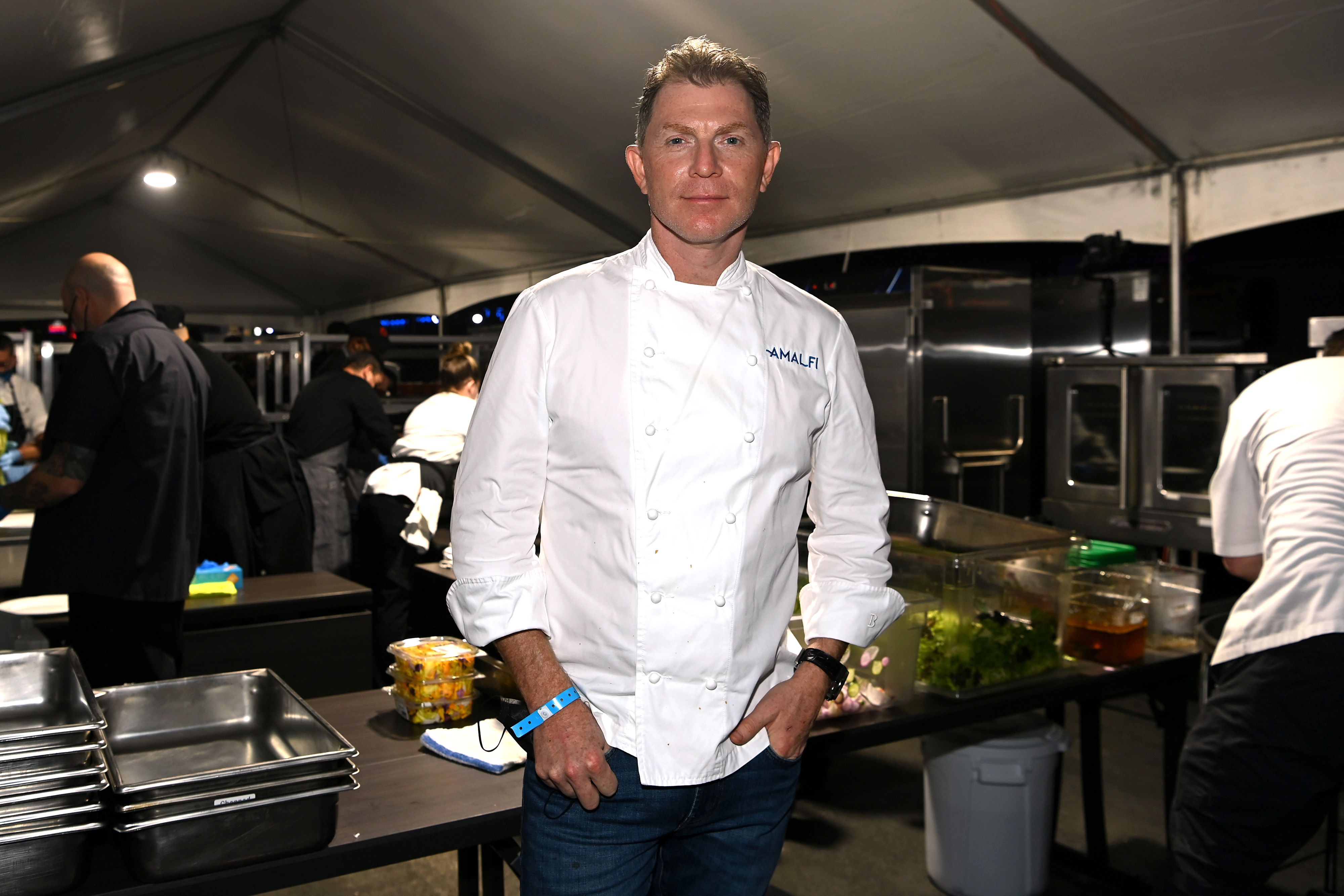 Food Network star Bobby Flay, who can boast a highly rated pizza dough recipe, stands in a kitchen in his chef whites.
