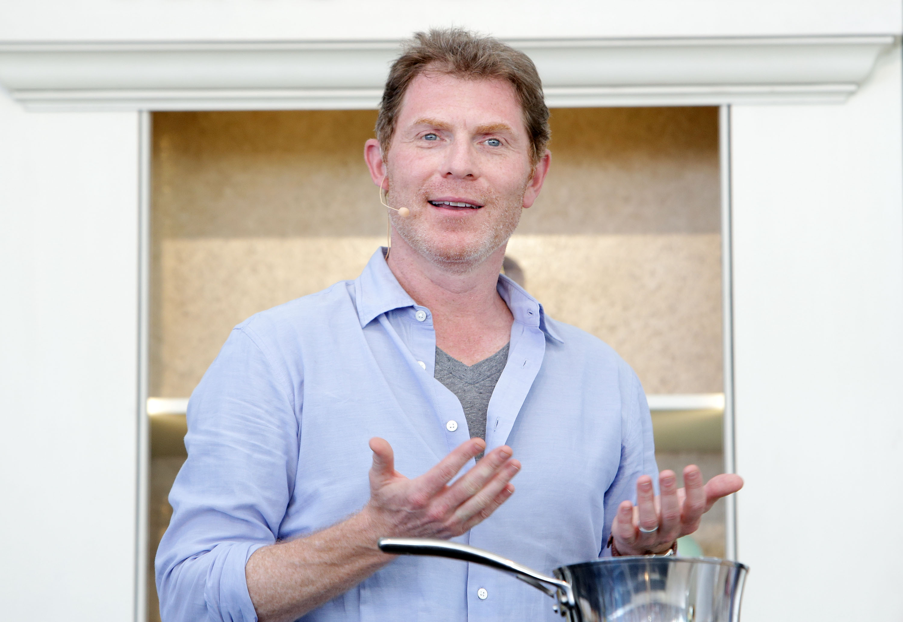 Food Network star Bobby Flay wears a light blue button-down shirt at a 2013 event.