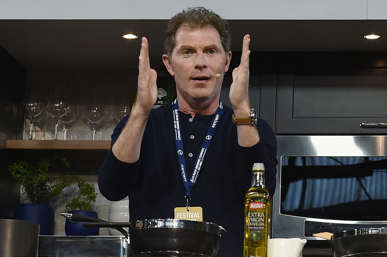 Chef Bobby Flay wears a long-sleeved dark shirt as he explains how to prepare a dish at a 2016 Food Network event.