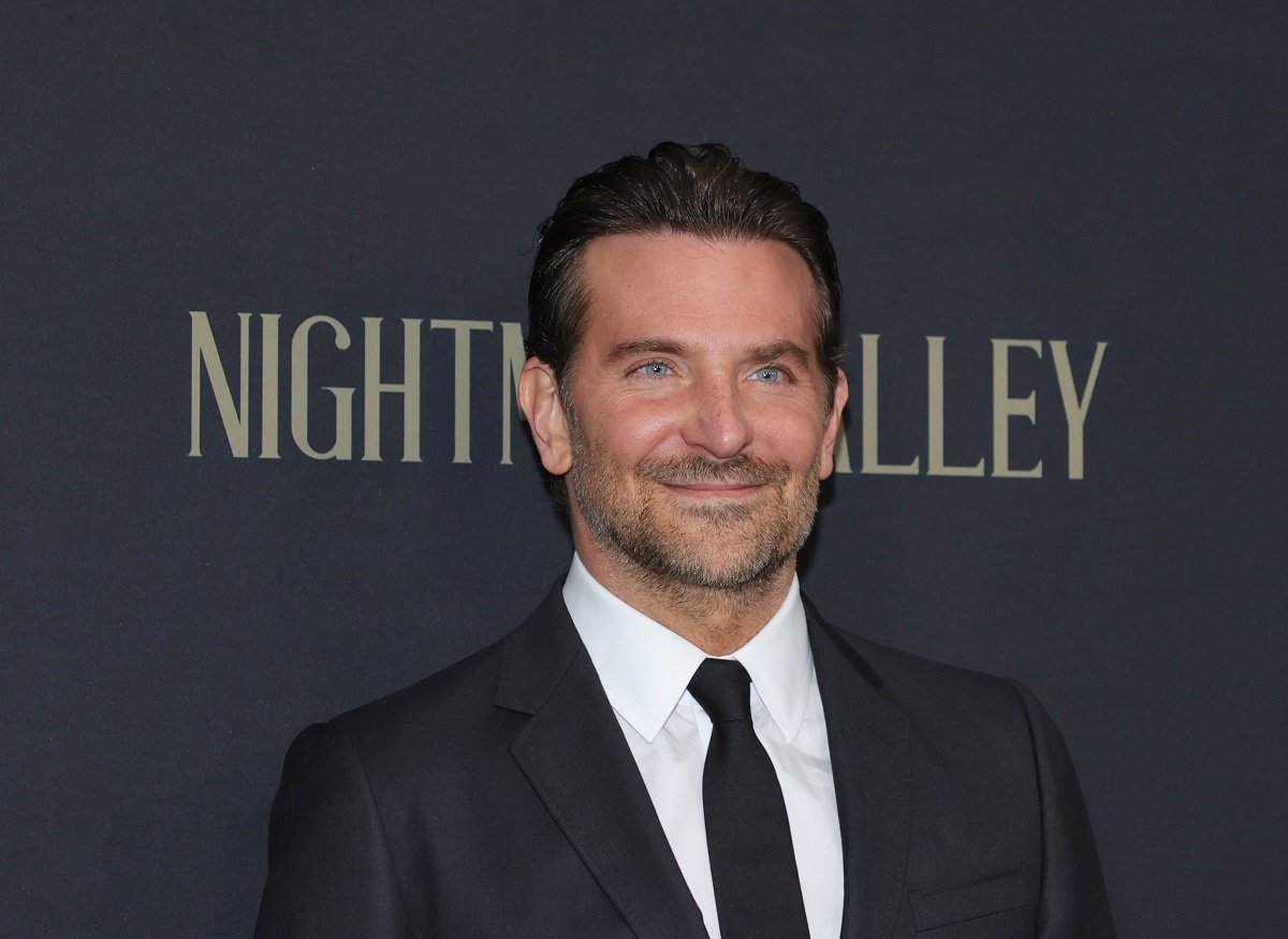 Bradley Cooper smiling while wearing a suit.