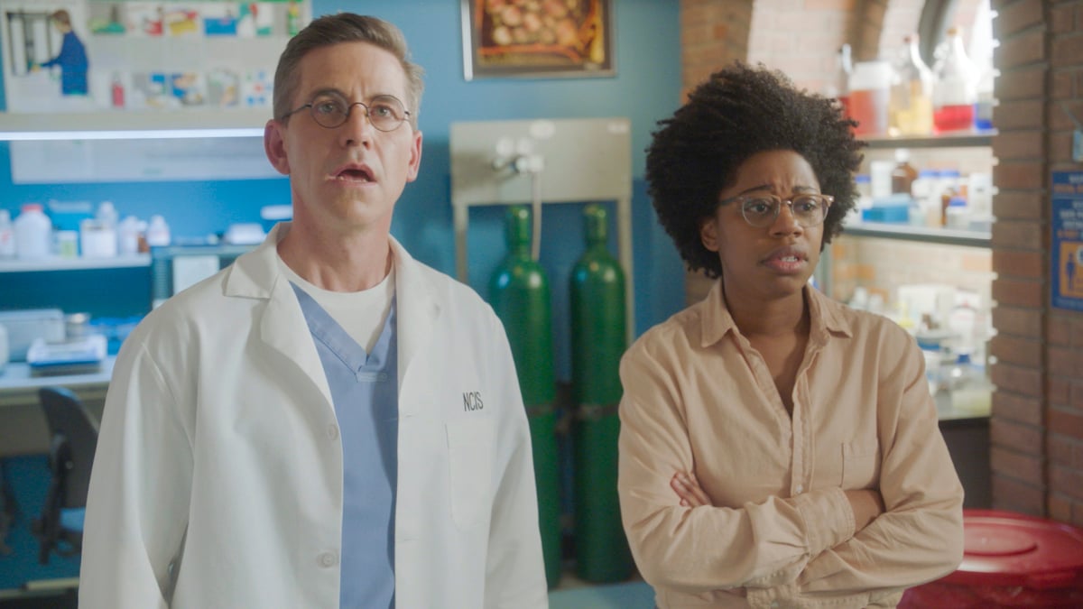 Brian Dietzen and Diona Reasonover stand in Kasie's lab on the set of 'NCIS.'