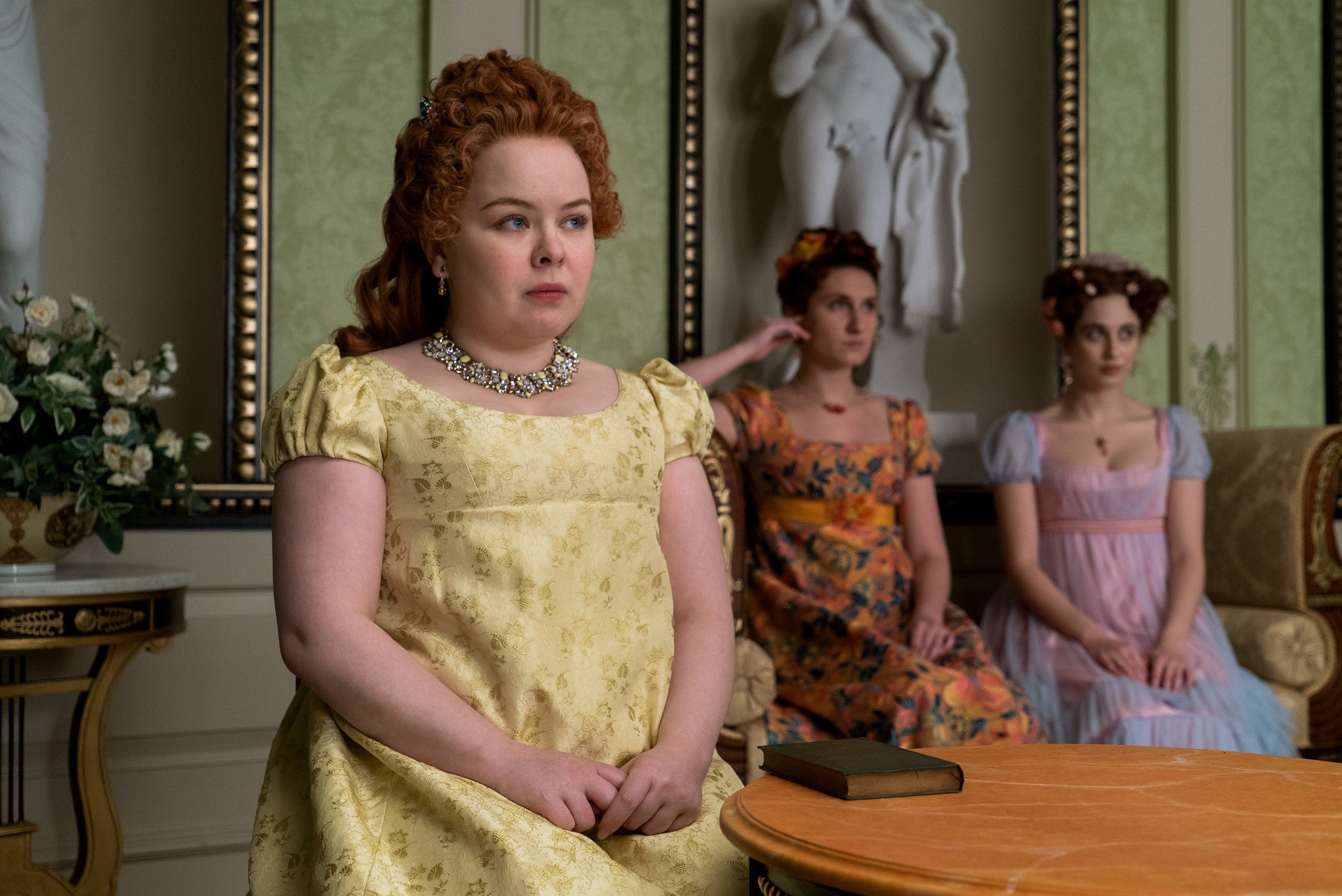 'Bridgerton': Nicola Coughlan sitting in a yellow dress looking worried in front of her sisters