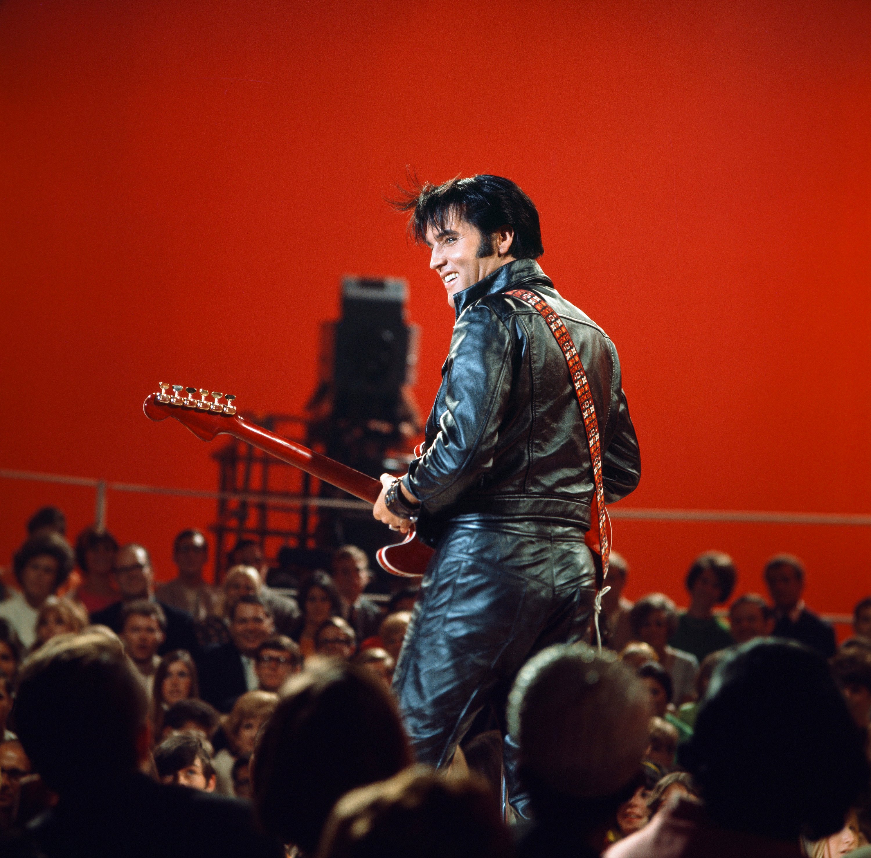 Elvis Presley performing songs in a black leather outfit