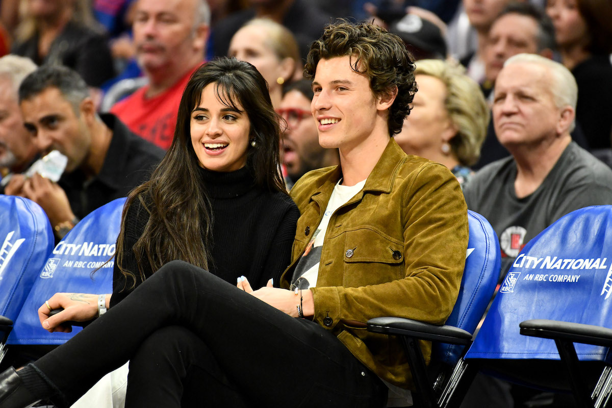 Camila Cabello and Shawn Mendes sit together at an event.