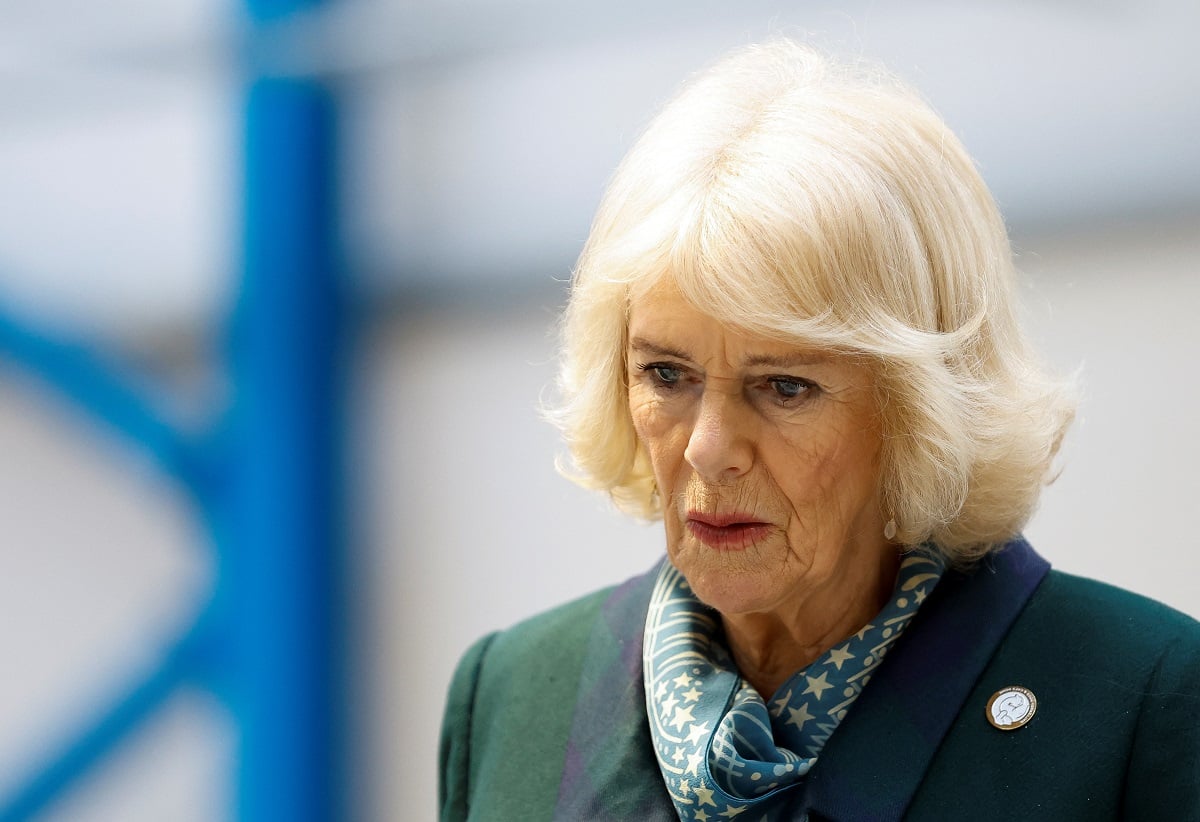 Camilla Parker Bowles dressed in a dark green coat and blue scarf during a visit to a U.K. airport