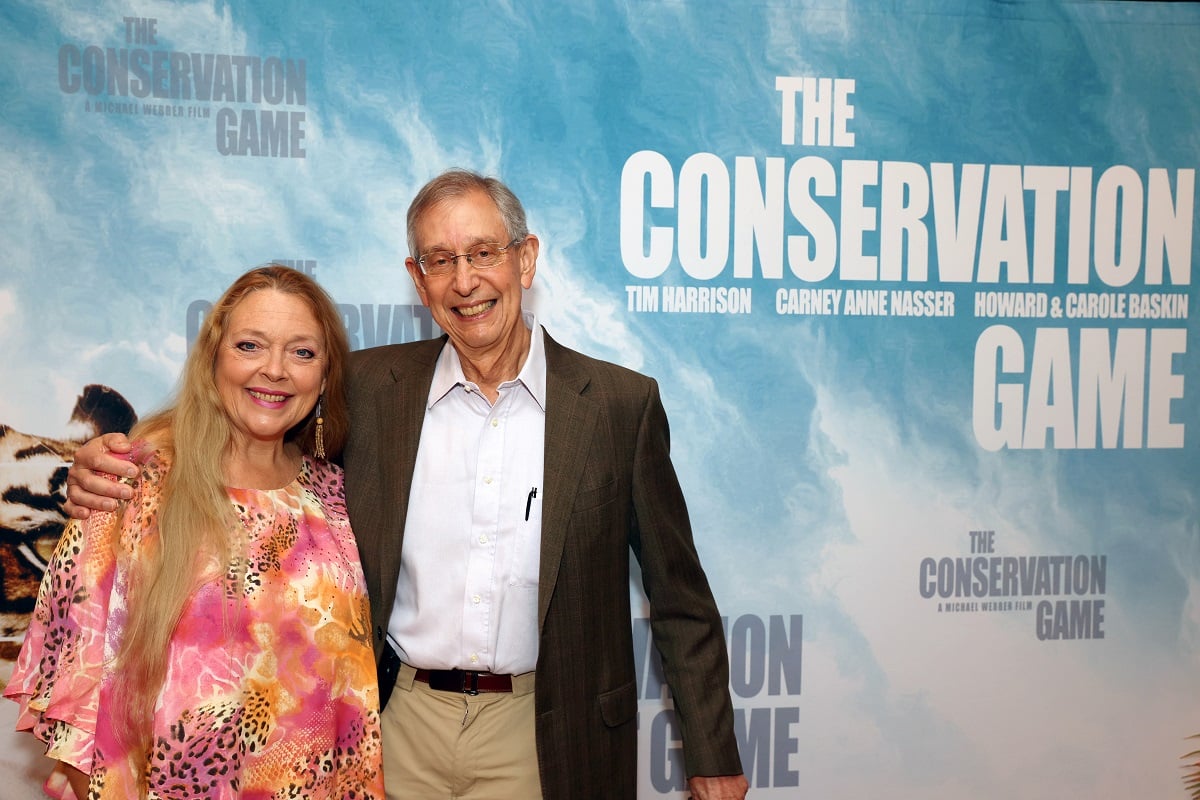 'Tiger King' star Carole Baskin in a pink animal print blouse, and Howard Baskin in khakis and a grey jacket at the film premiere of 'The Conservation Game.'