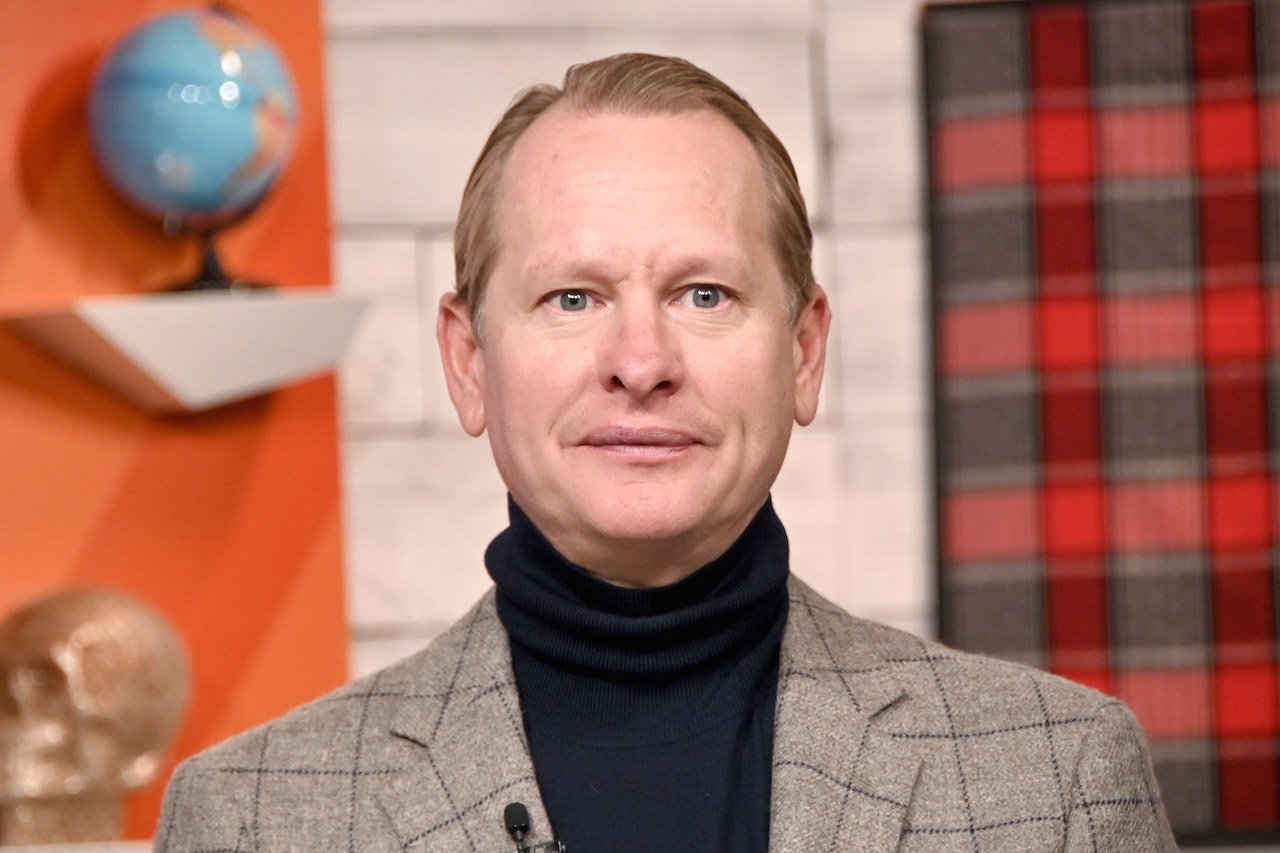 Carson Kressley visits BuzzFeed's "AM TO DM' in a black turtleneck and grey blazer.