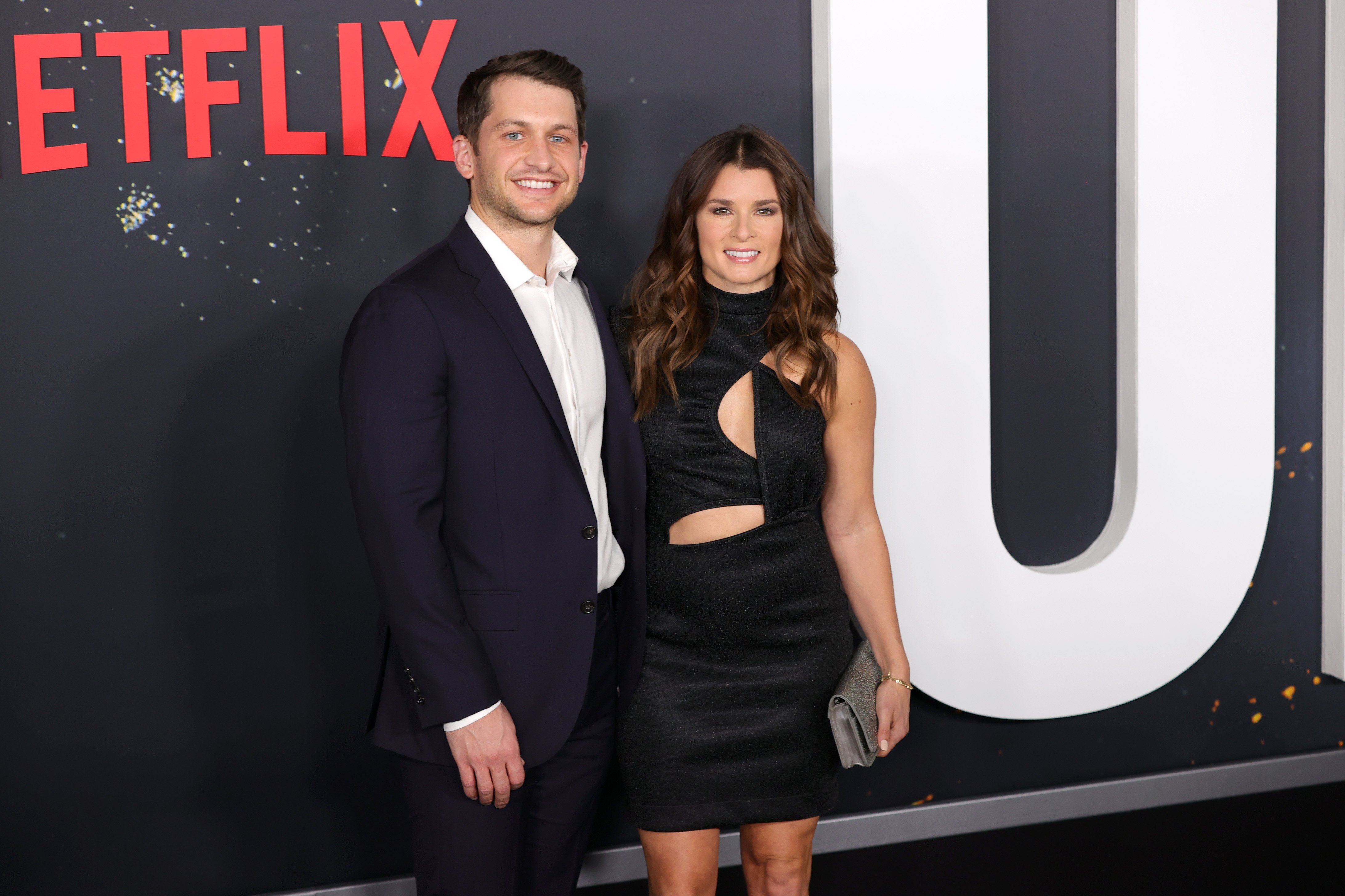 Carter Comstock and Danica Patrick pose together on the carpet at the world premiere of Netflix's Don't Look Up