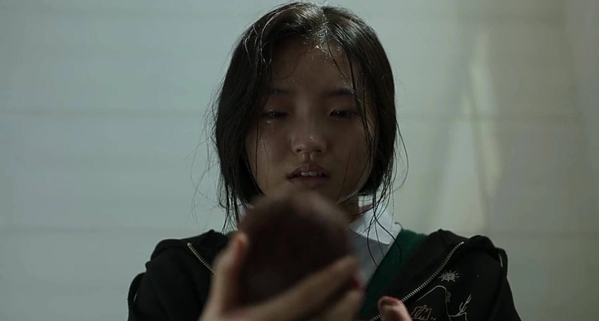 Character Hee-soo in 'All of Us Are Dead' holding baby in relation to K-drama director.