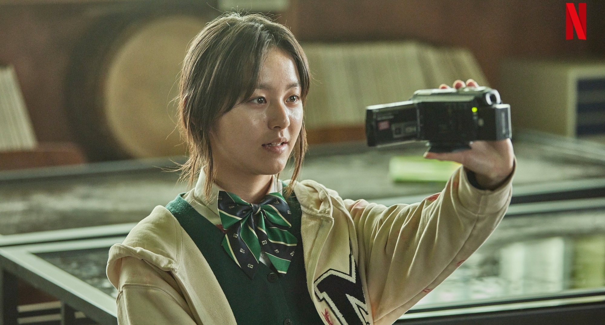 Character On-jo in 'All of Us Are Dead' K-drama holding video camera.