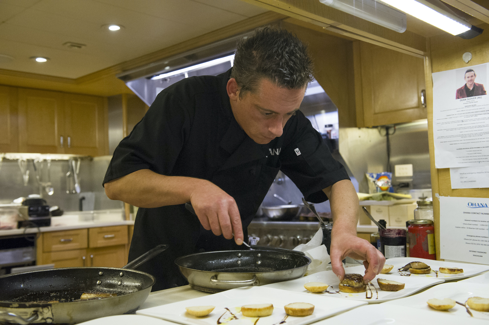Chef Ben Robinson from 'Below Deck' plates food on a yacht.