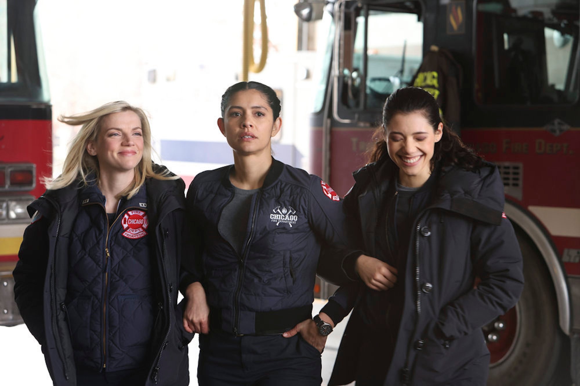 Sylvie Brett, Stella Kidd, and Violet Mikami standing together arm-in-arm and smiling in 'Chicago Fire' Season 10