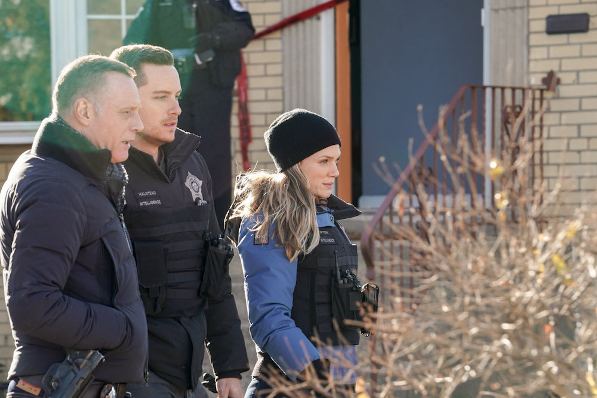 Jason Beghe as Hank Voight, Jesse Lee Soffer as Jay Halstead, and Tracy Spiridakos as Hailey Upton standing together in 'Chicago P.D.' Season 9
