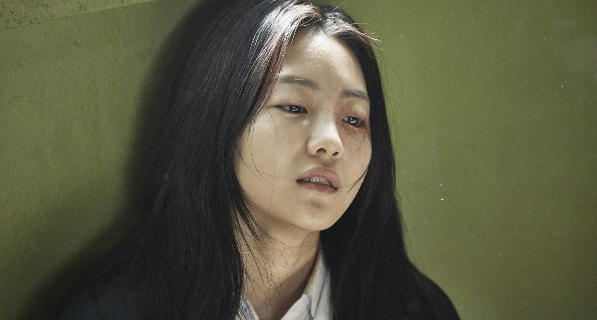 Cho Yi-hyun as Nam-ra in 'All of Us are Dead' sitting against classroom wall.