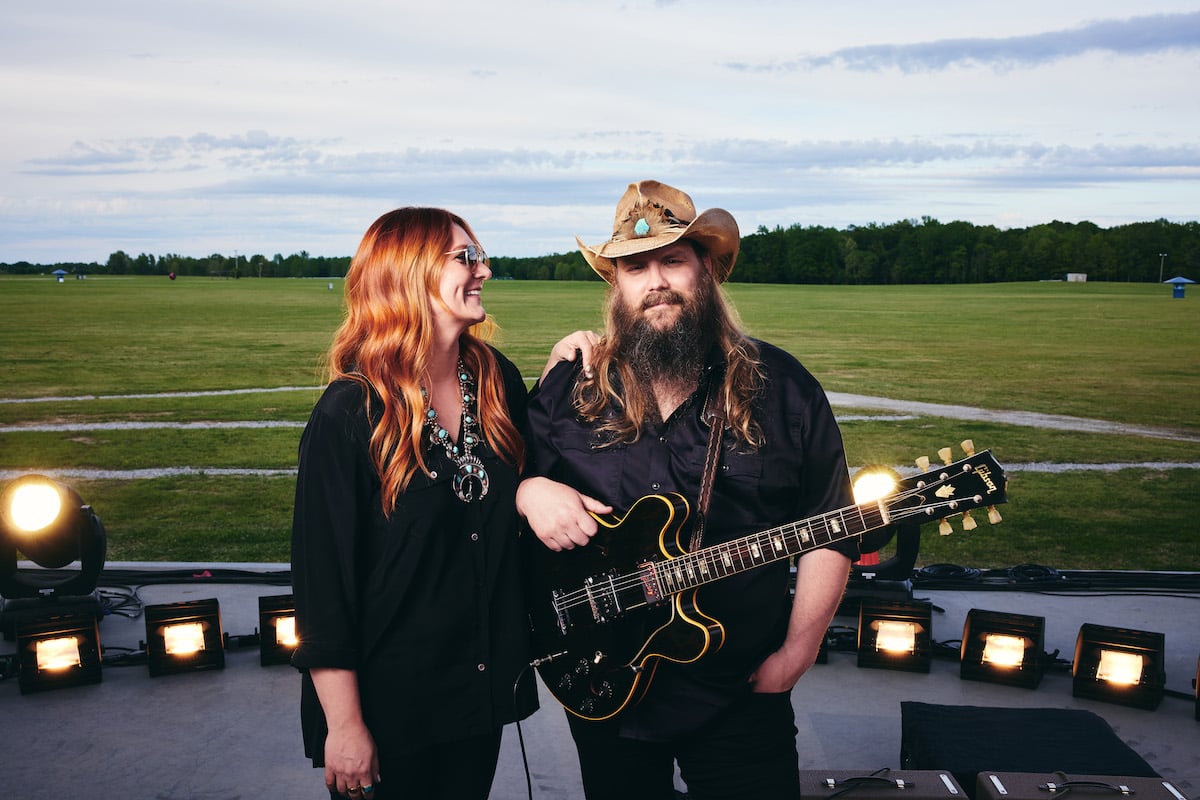 Chris Stapleton and Morgane Stapleton smiling on an outdoor stage