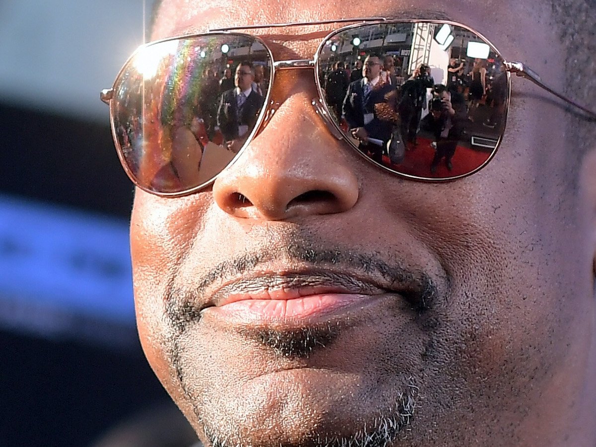 Chris Tucker smiles in a close-up while wearing sunglasses