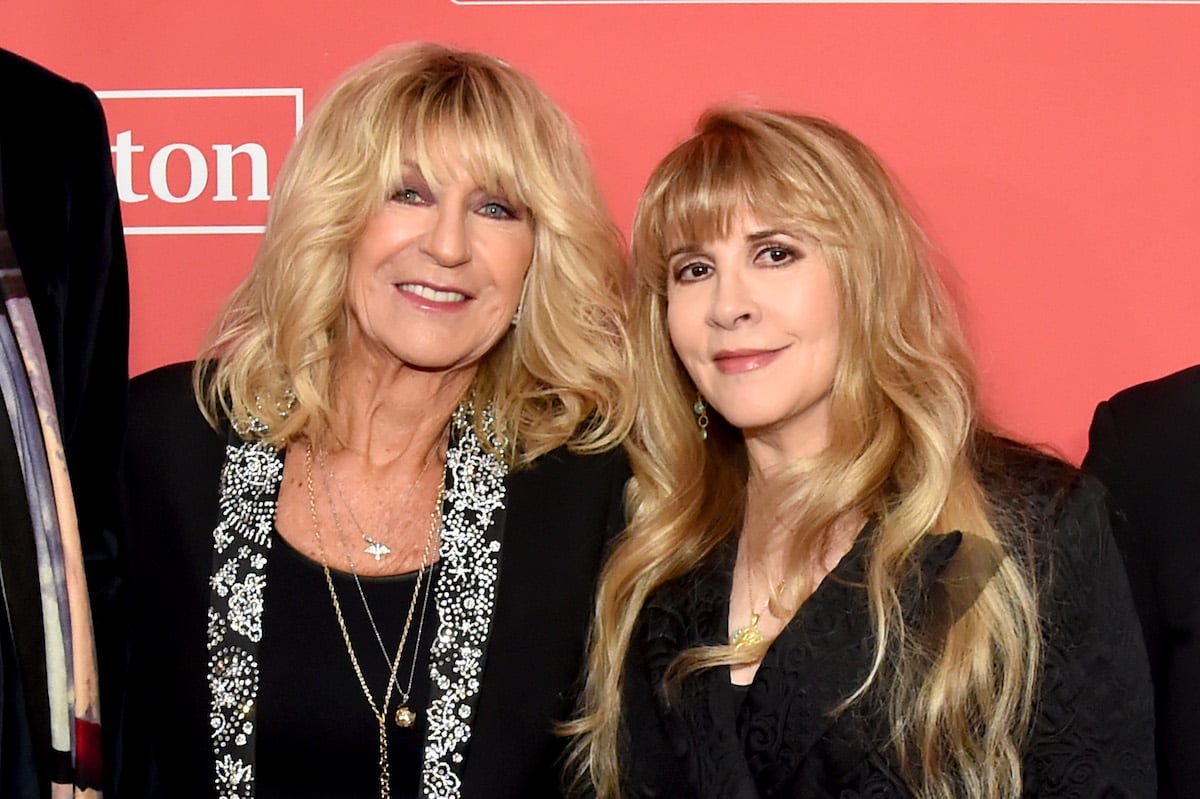 Christine McVie and Stevie Nicks smile at an event.