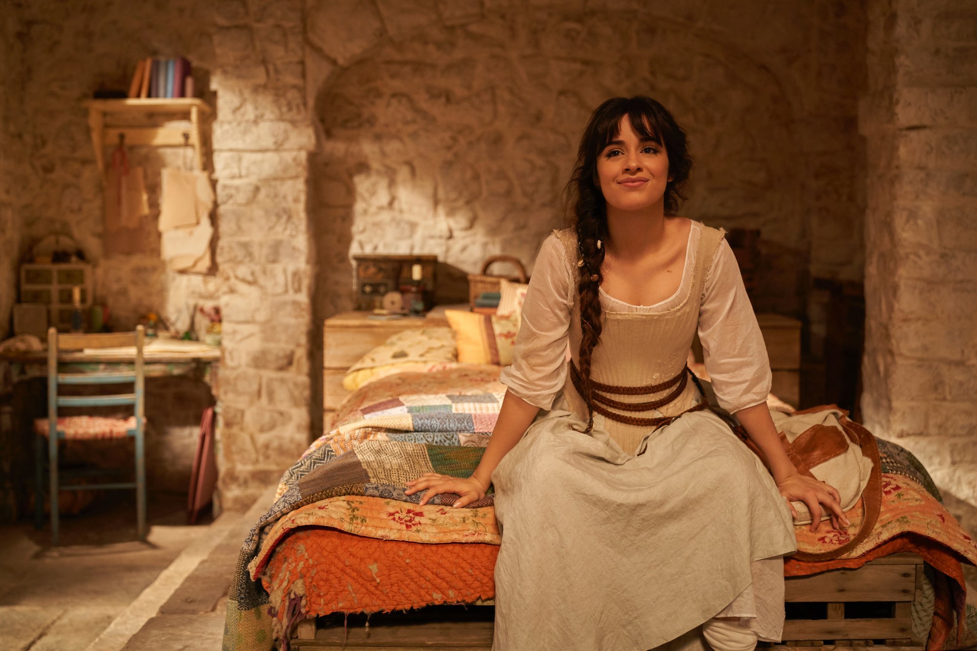 'Cinderella' star Camila Cabello as Cinderella in article about Oscars 2022 Fan Favorite smiling sitting on the bed