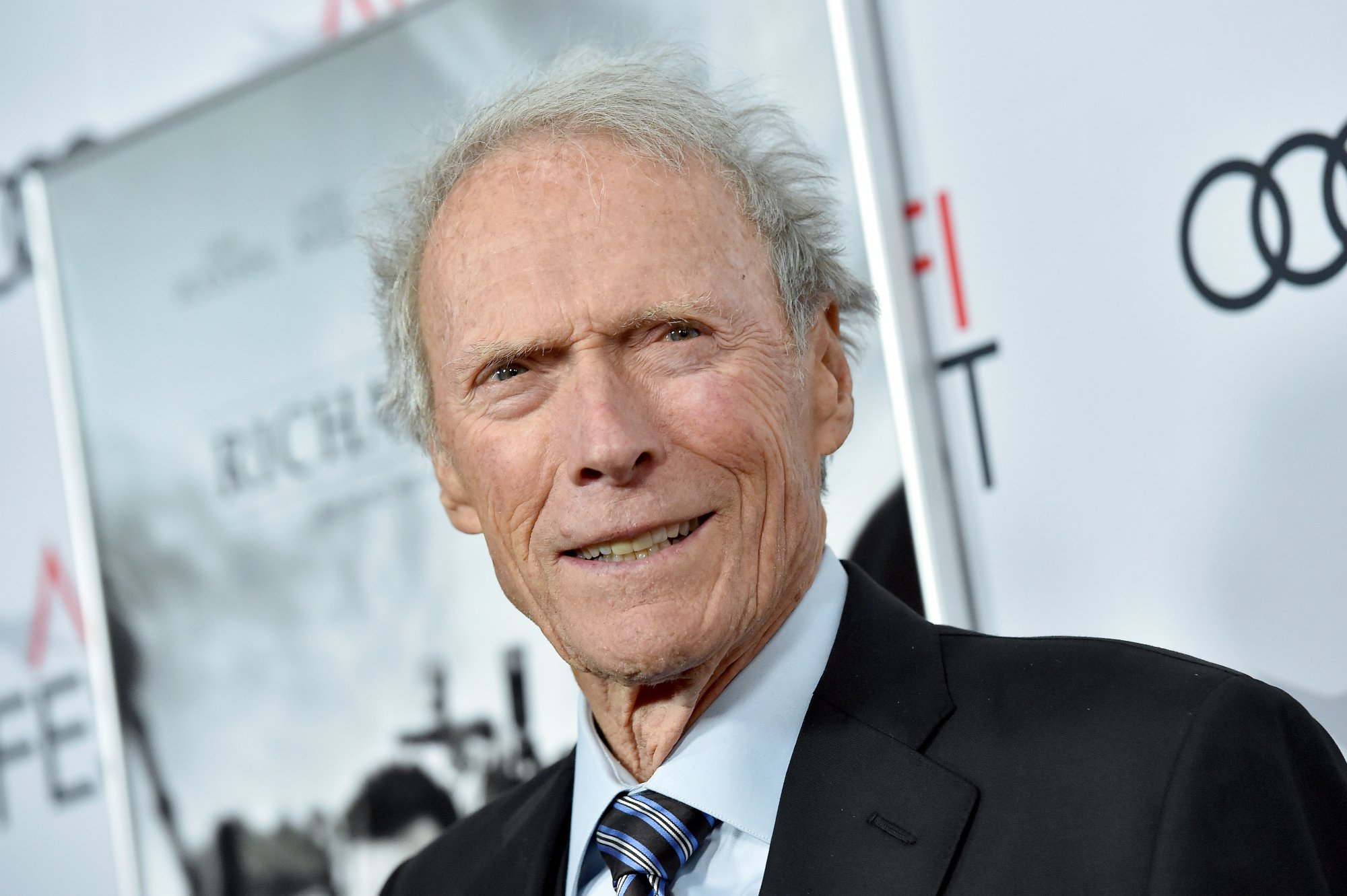 Clint Eastwood in article about new generation smiling in front of AFI Fest step and repeat