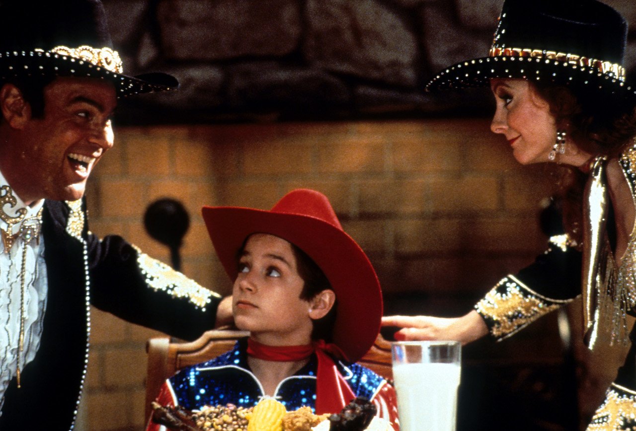 Dan Aykroyd smiles at Elijah Wood with Reba McEntire in a scene from the film 'North', 1994.