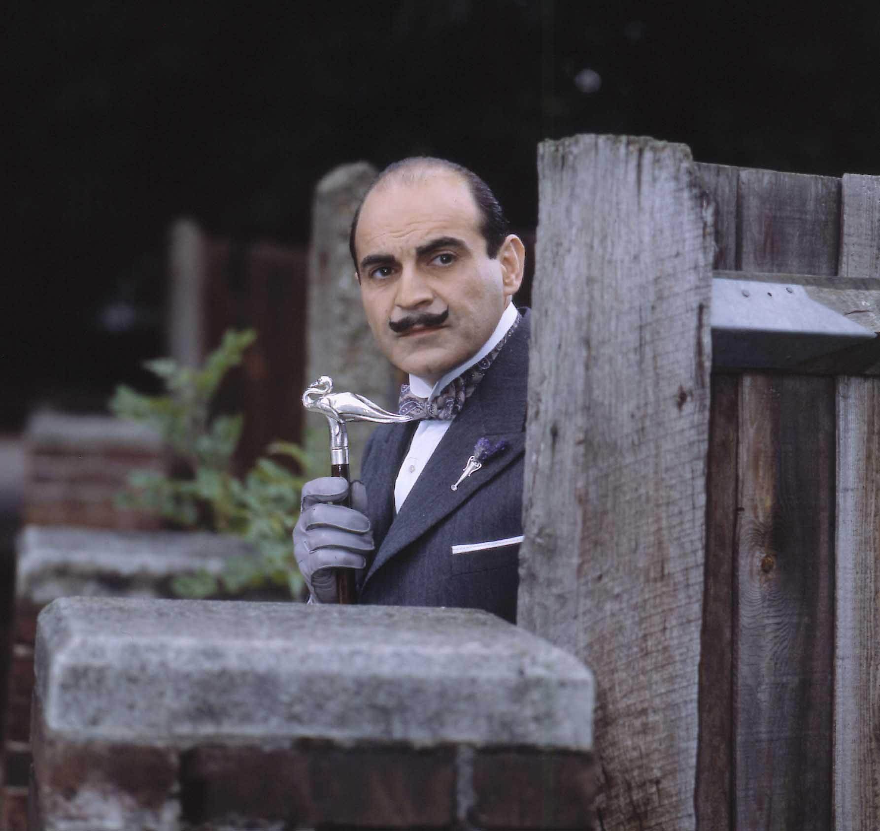David Suchet as Hercule Poirot, holding a cane