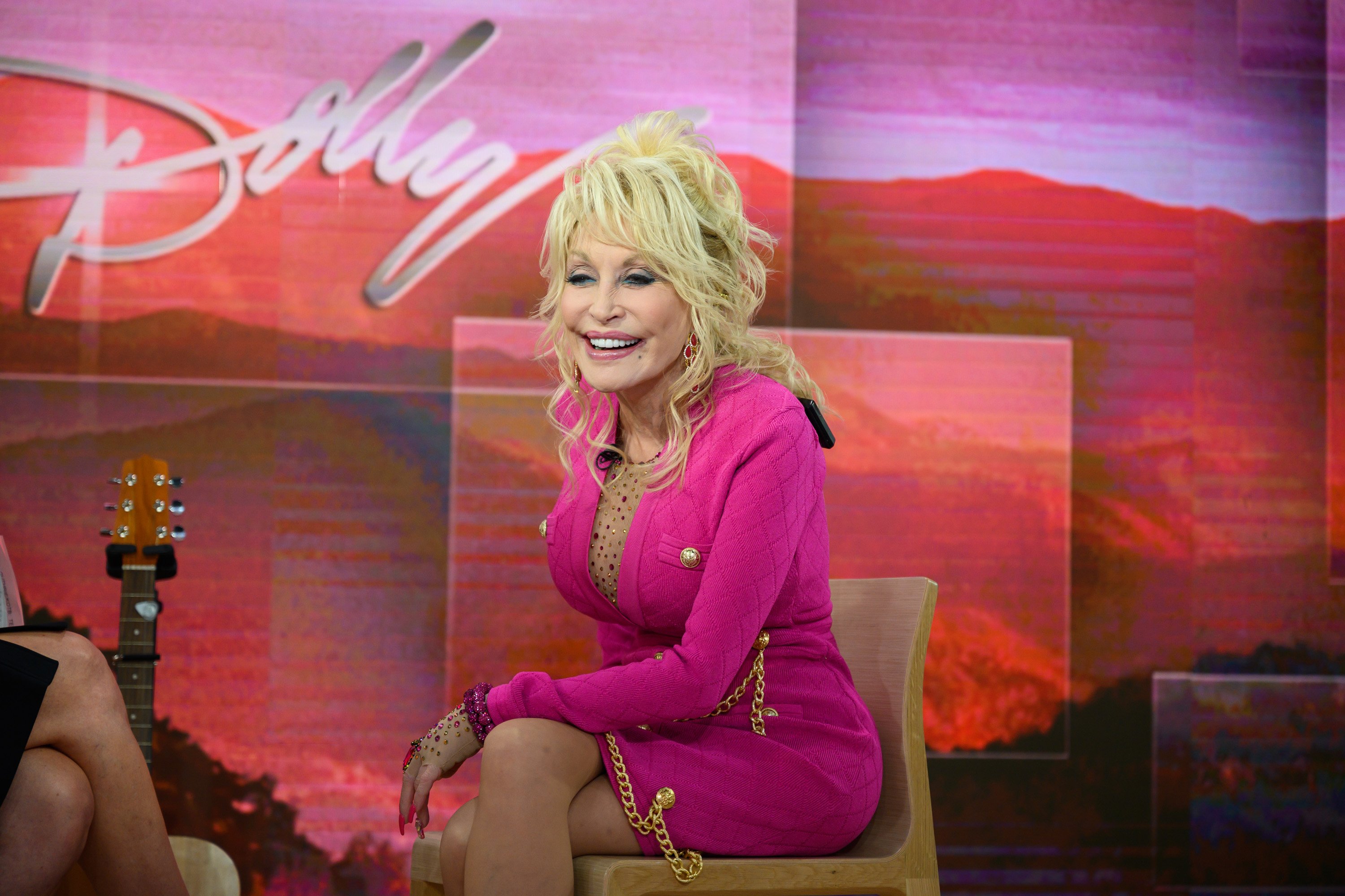 Dolly Parton talks to the Today show hosts while wearing a pink outfit.
