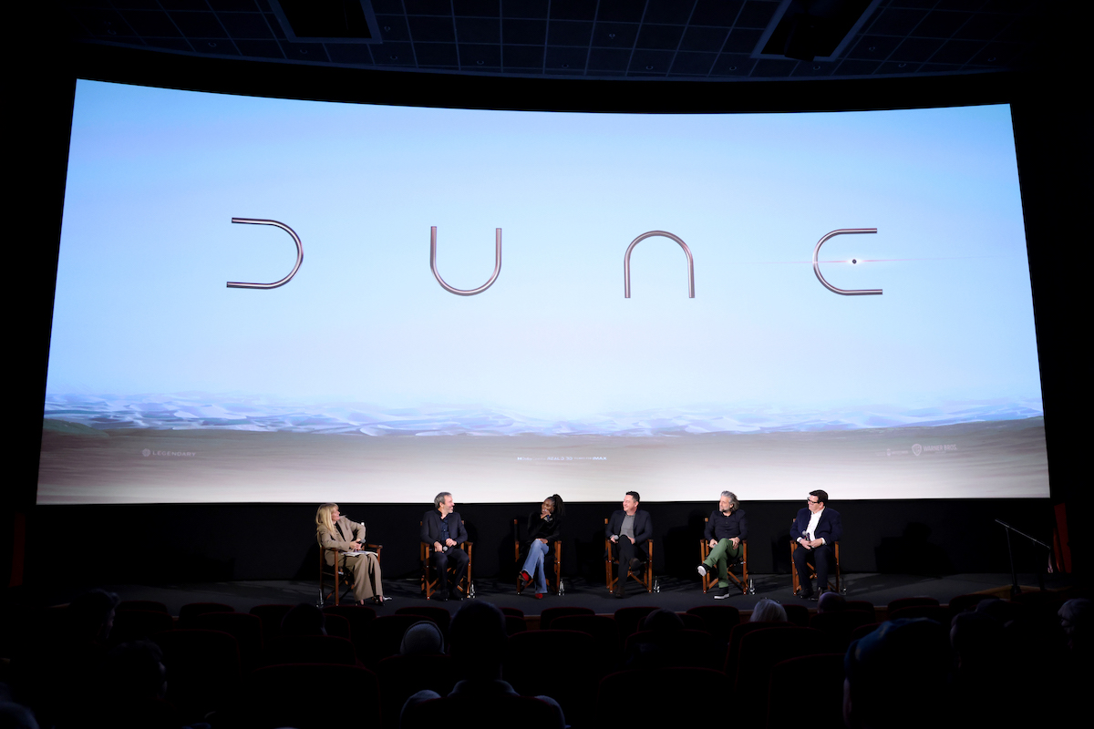 Edith Bowman, Denis Villeneuve, Sharon Duncan-Brewster, Greig Fraser, Paul Lambert, and Donald Mowat sit in chairs onstage under the ‘Dune’ logo