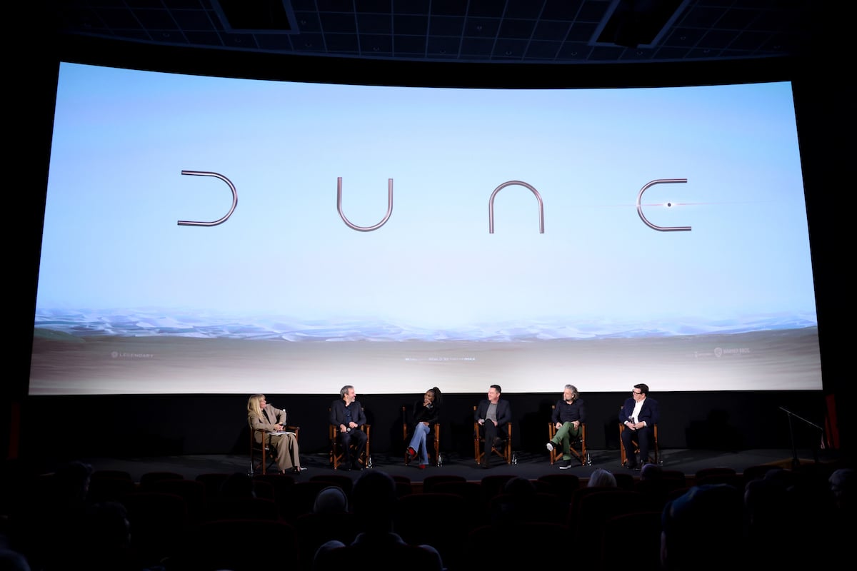 Edith Bowman, Denis Villeneuve, Sharon Duncan-Brewster, Greig Fraser, Paul Lambert, and Donald Mowat sit in chairs onstage under the ‘Dune’ logo