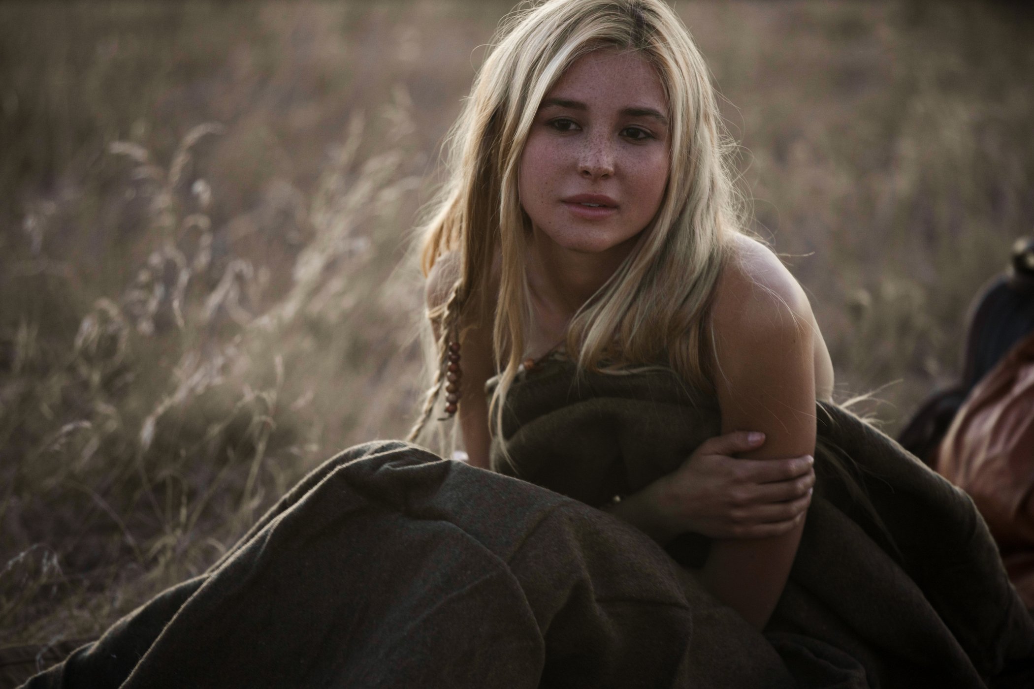 Elsa Dutton in '1883' Episode 8 sitting in a field with a blanket covering her