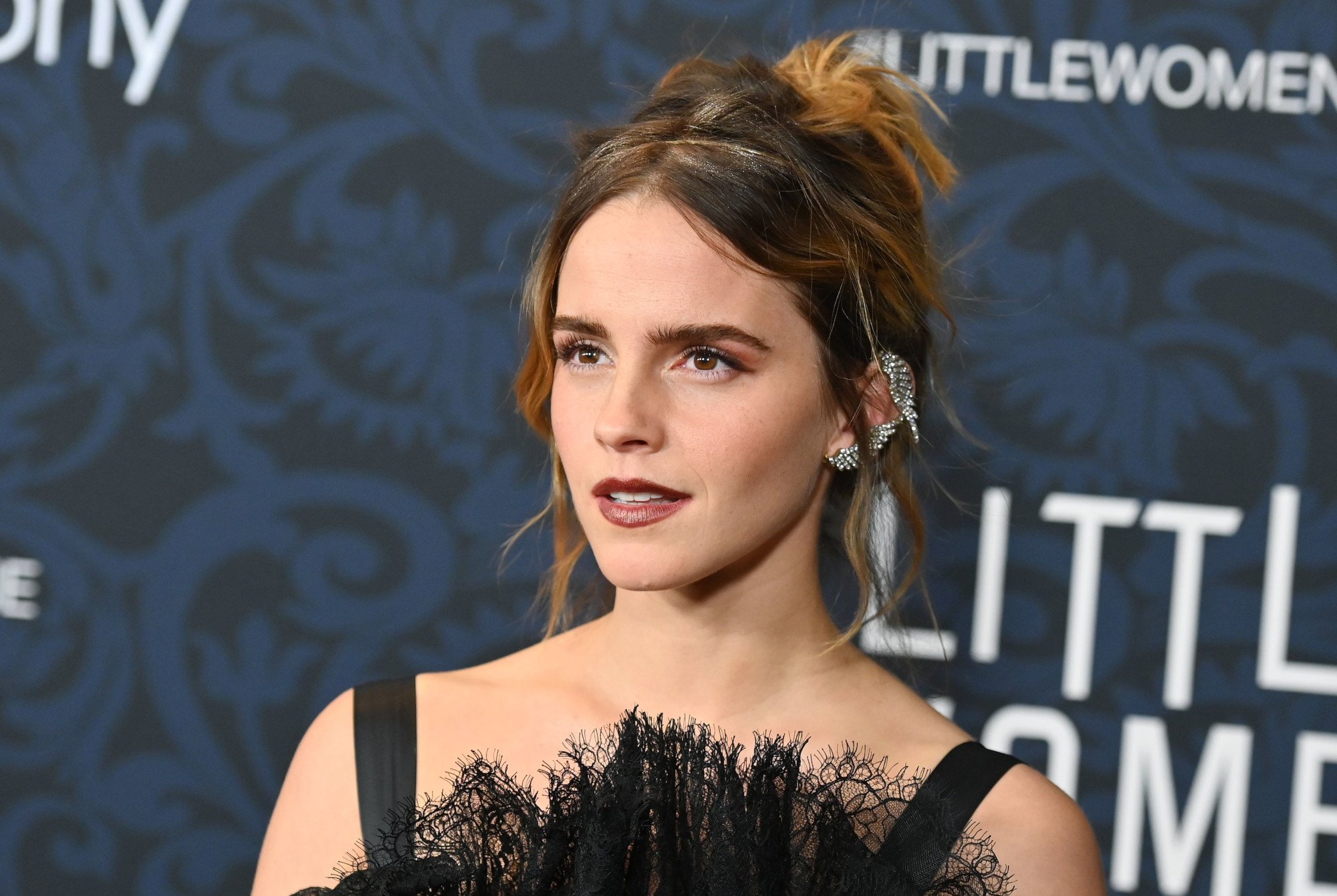 'Harry Potter' star Emma Watson. She's wearing a black dress and her hair is up.