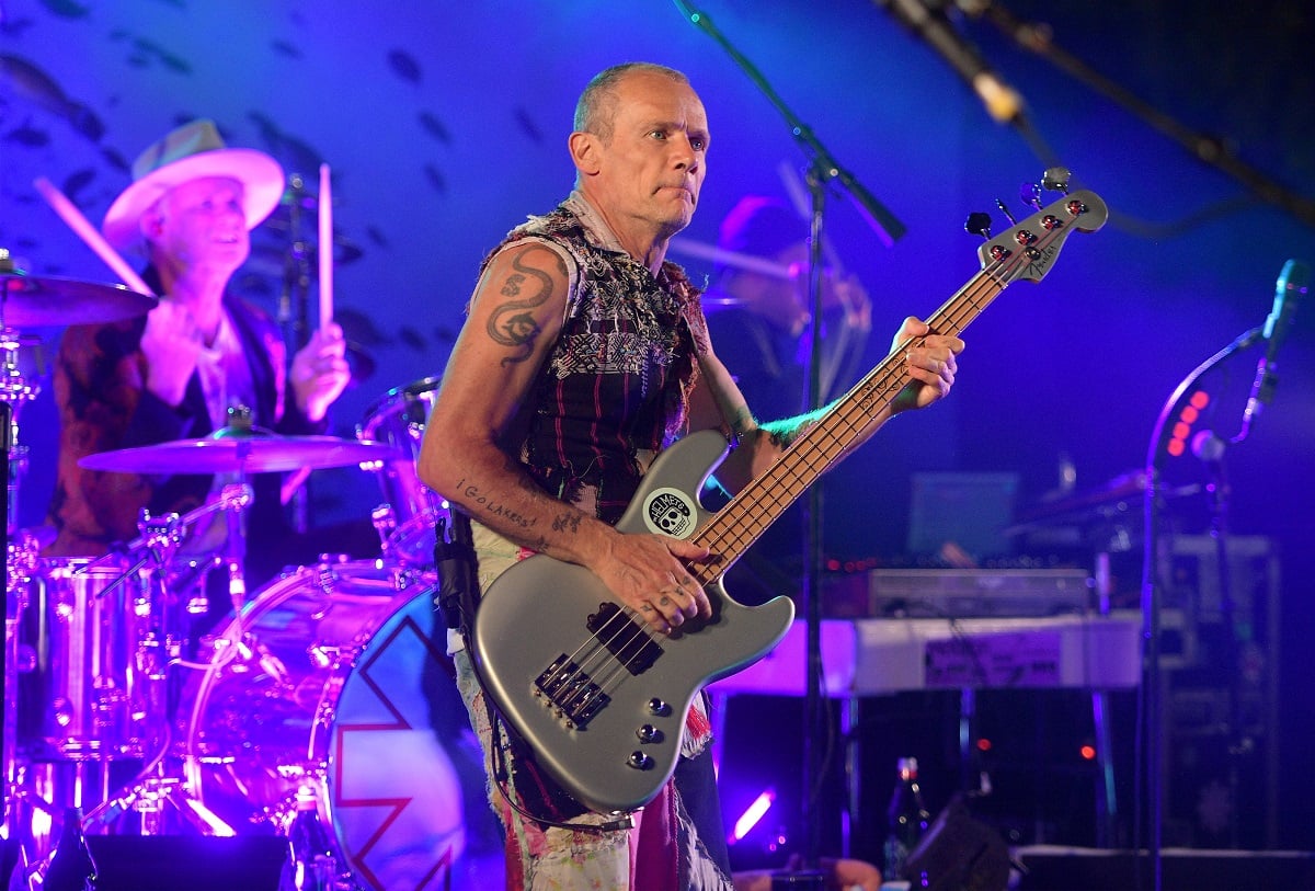 Flea of the Red Hot Chili Peppers playing his guitar on stage 