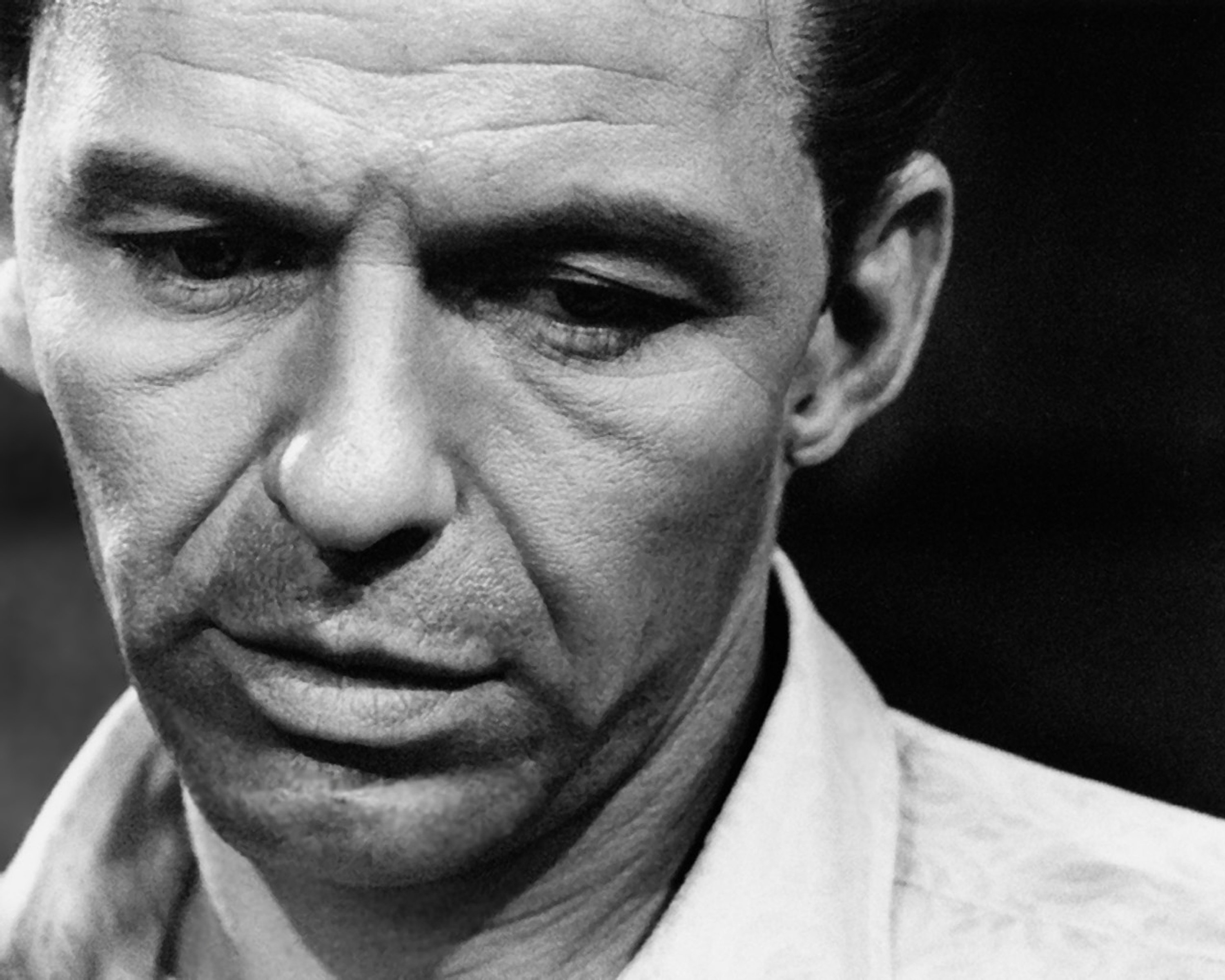 A black and white picture of Frank Sinatra wearing a white collared shirt.