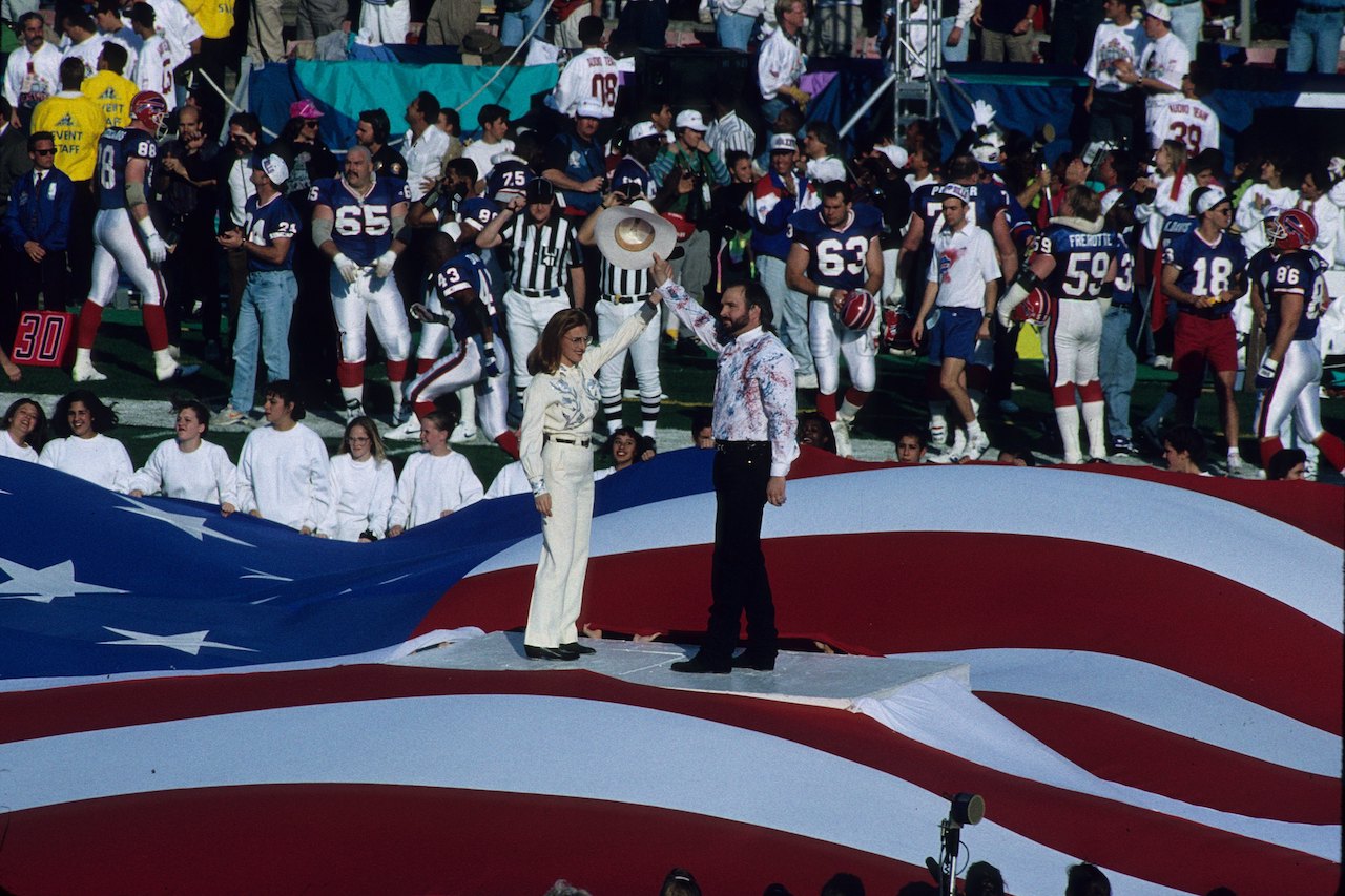 Marlee Matlin and Garth Brooks join hands after their performance of the national anthem at the Super Bowl