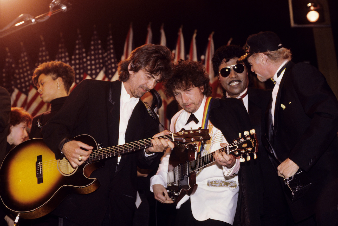 George Harrison and Bob Dylan performing in suits at the 1988 Rock & Roll Hall of Fame inductions.
