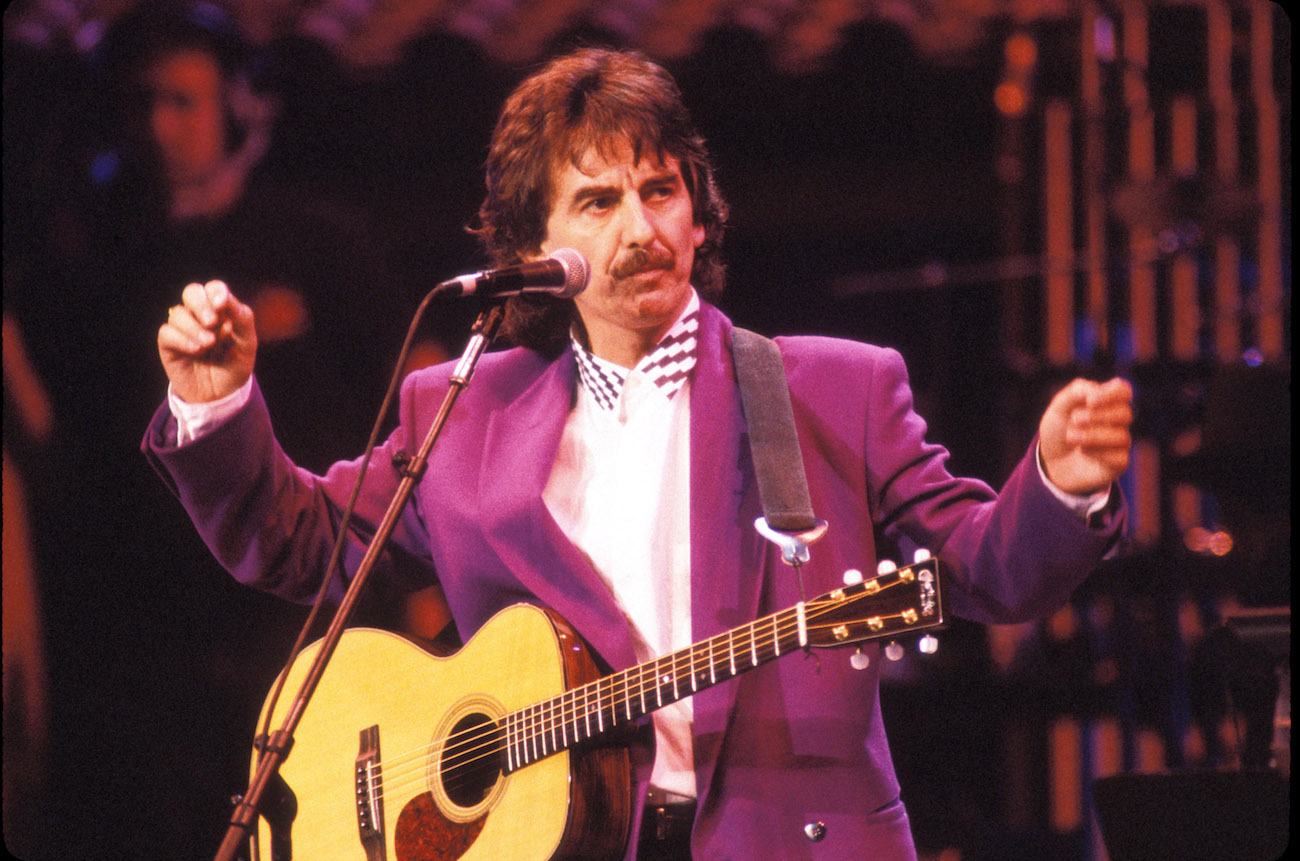 George Harrison wearing a purple suit while performing during Bob Dylan's 30th anniversary celebration in 1992. 