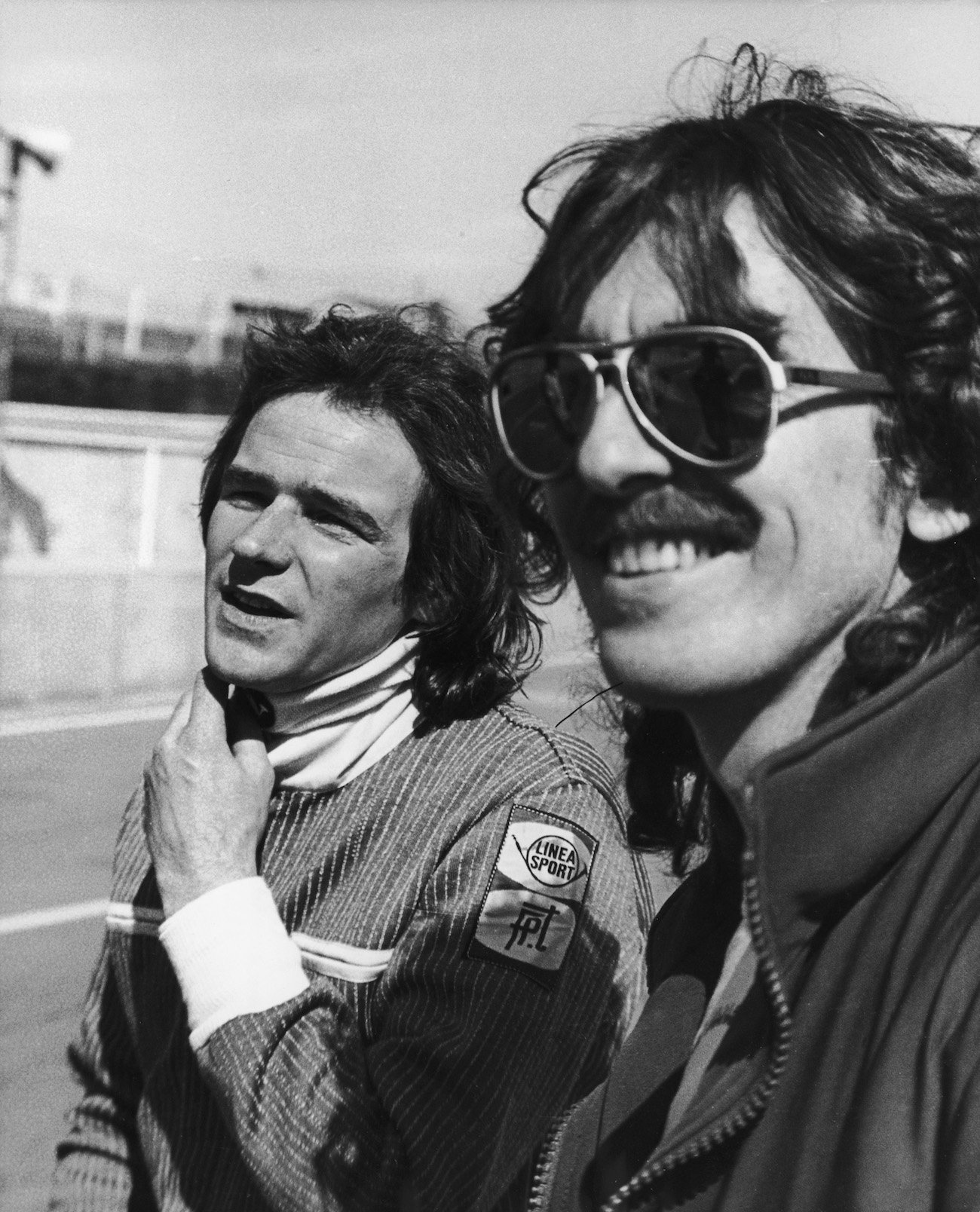 George Harrison wearing sunglasses with Formula One drive, Barry Sheene, at Brands Hatch in 1978.