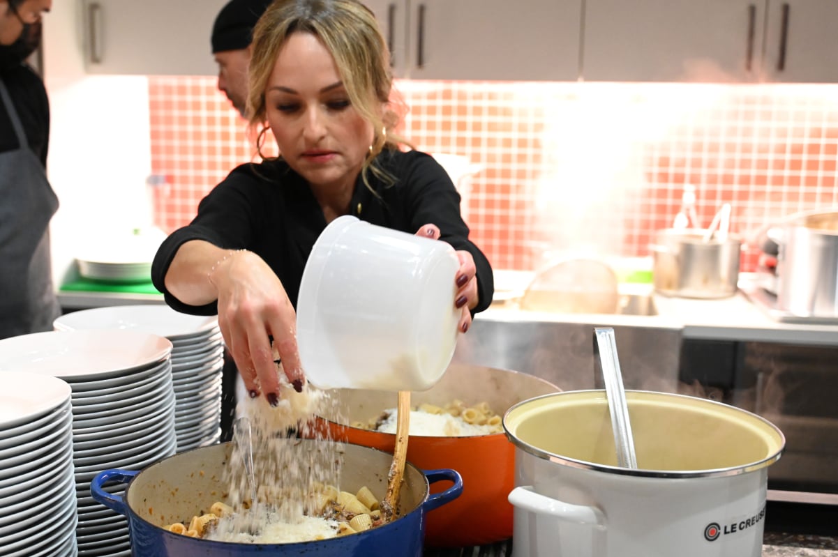 Food Network chef Giada De Laurentiis prepares a meal wearing a chef's jacket.