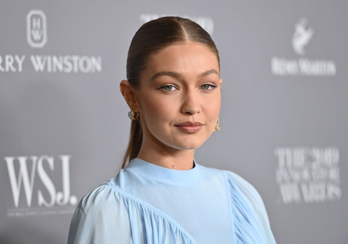 Gigi Hadid smiling in front of a gray background