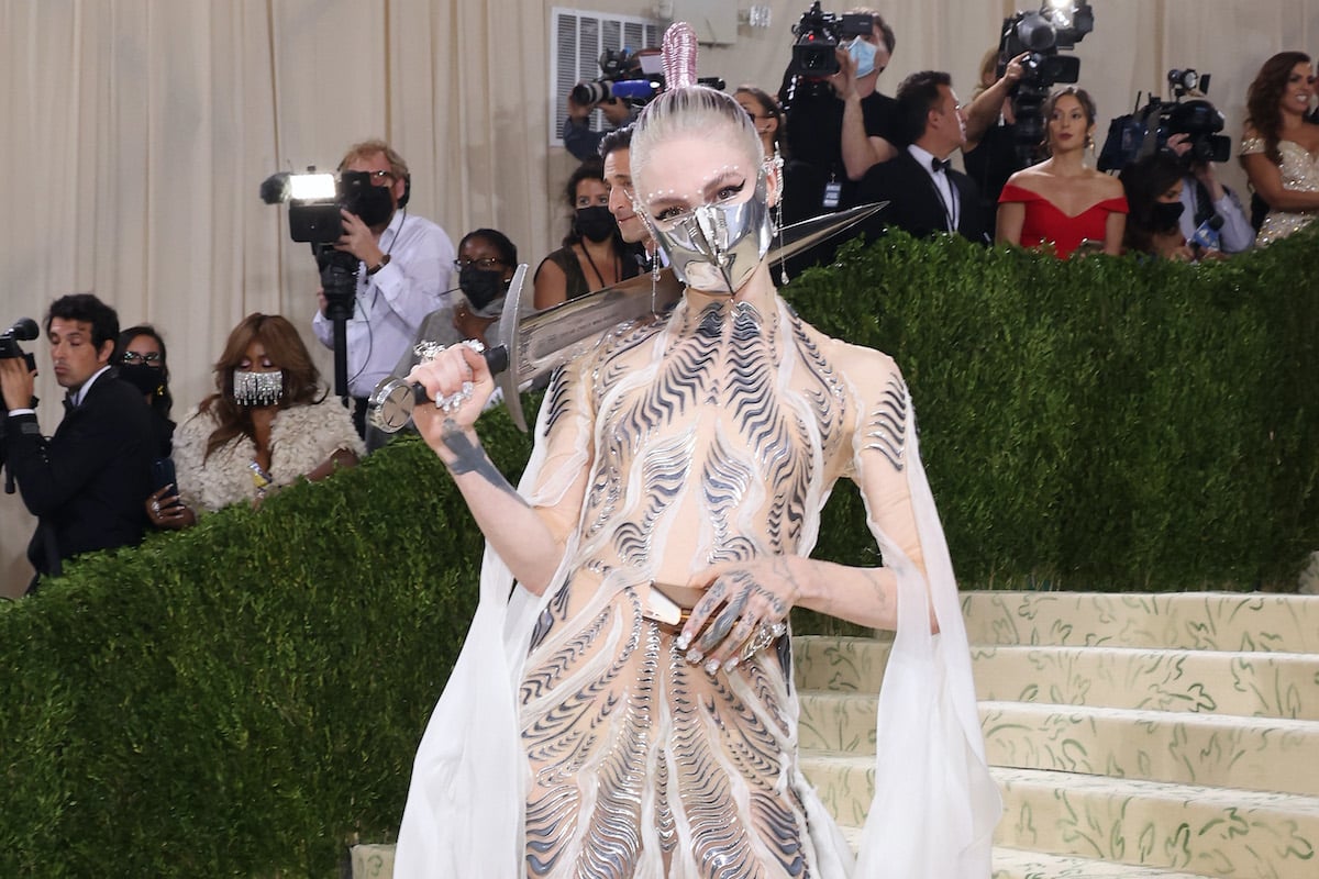 Grimes wearing a silver face mask, holding a sword