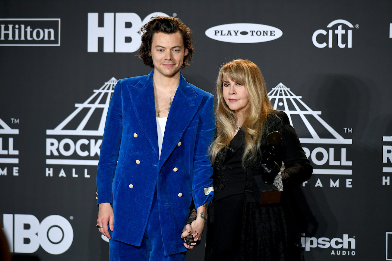 Harry Styles wearing a blue suit and Stevie Nicks in a black dress at the 2019 Rock & Roll Hall of Fame inductions.